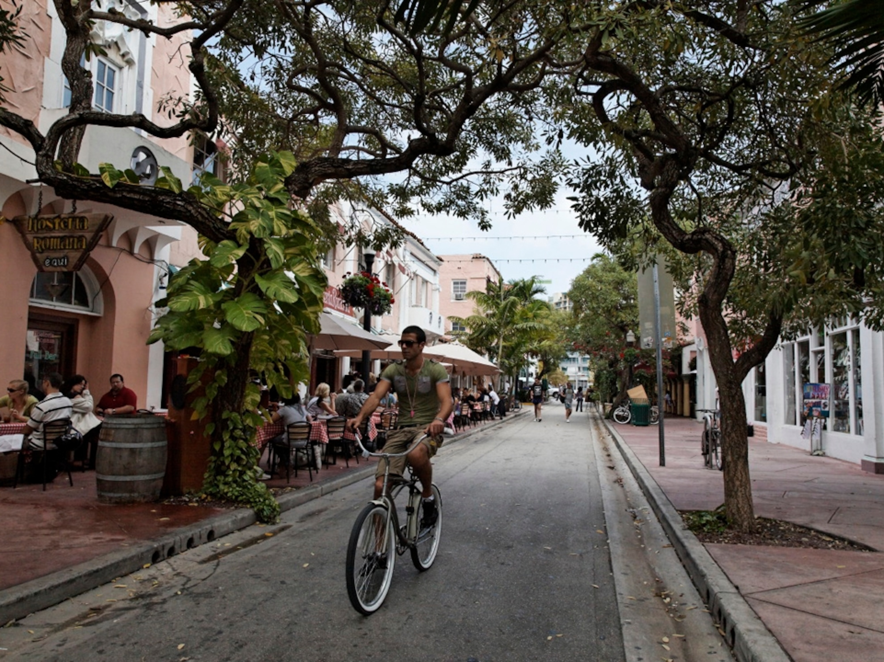 Man on bike rides down Espanola Way, Miami