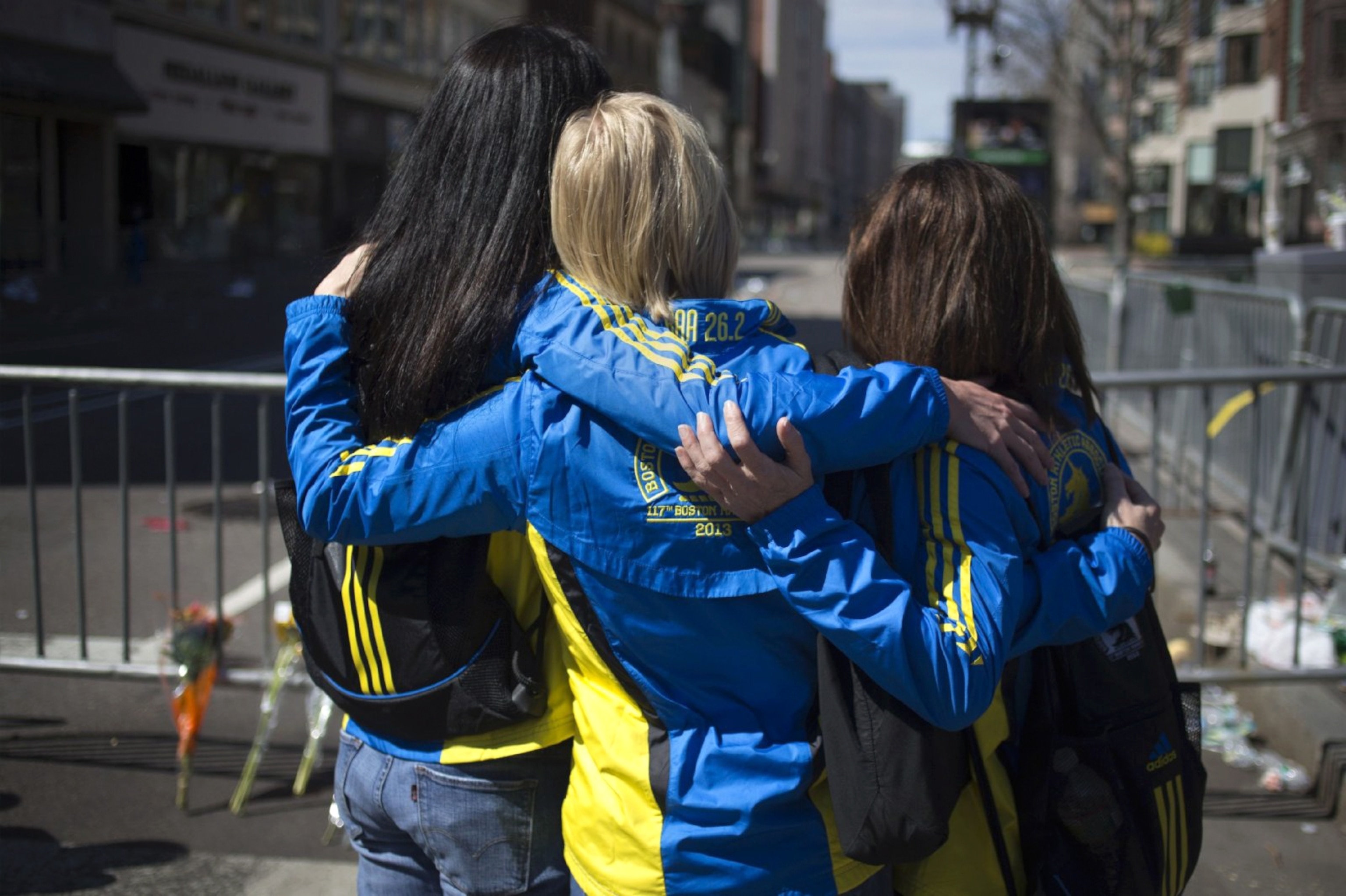 This Week in Boston - Three women embrace on a street in Boston.