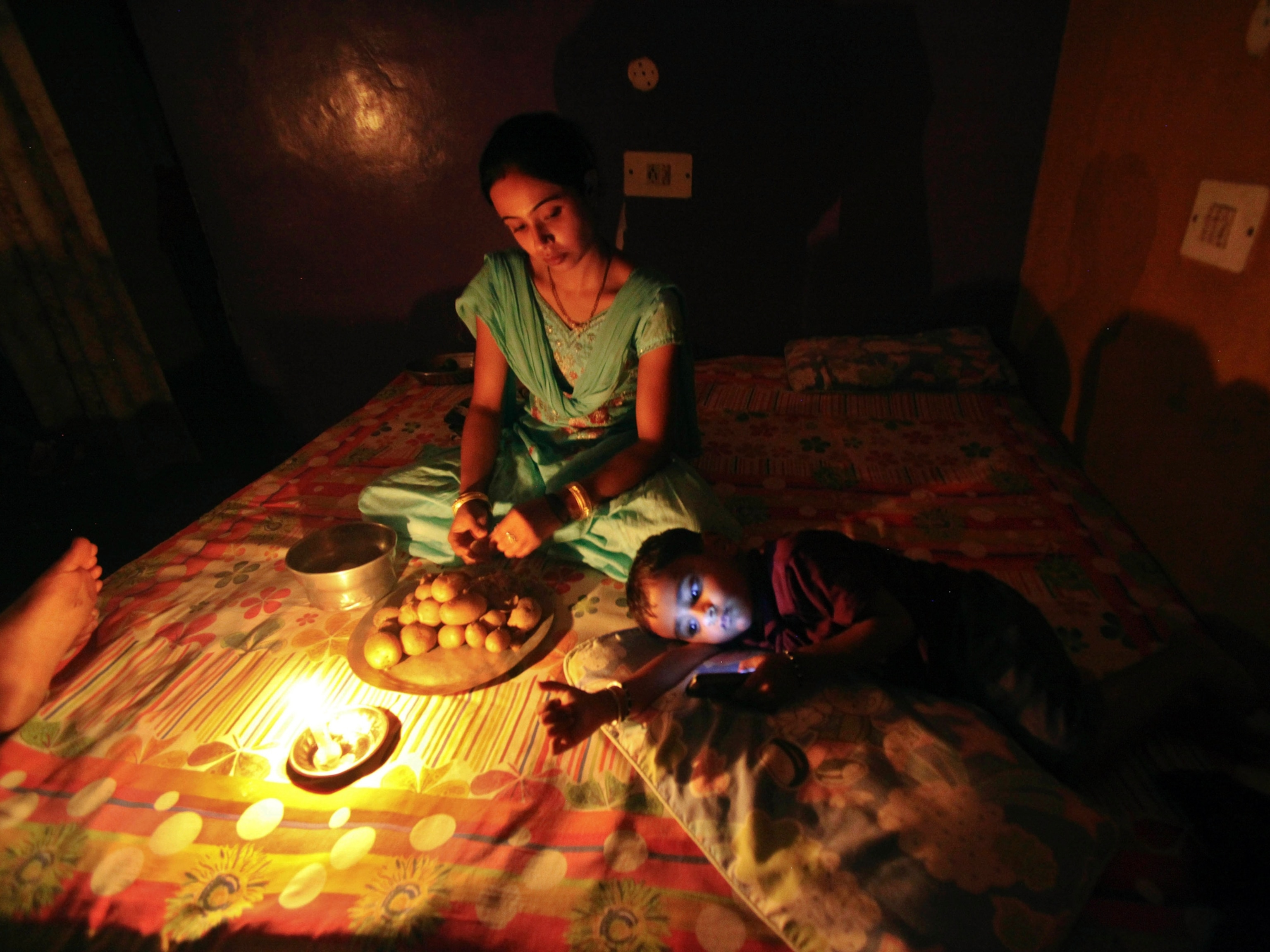 India blackout picture - an Indian girl prepares a meal by candlelight during a power cut in Jammu, India