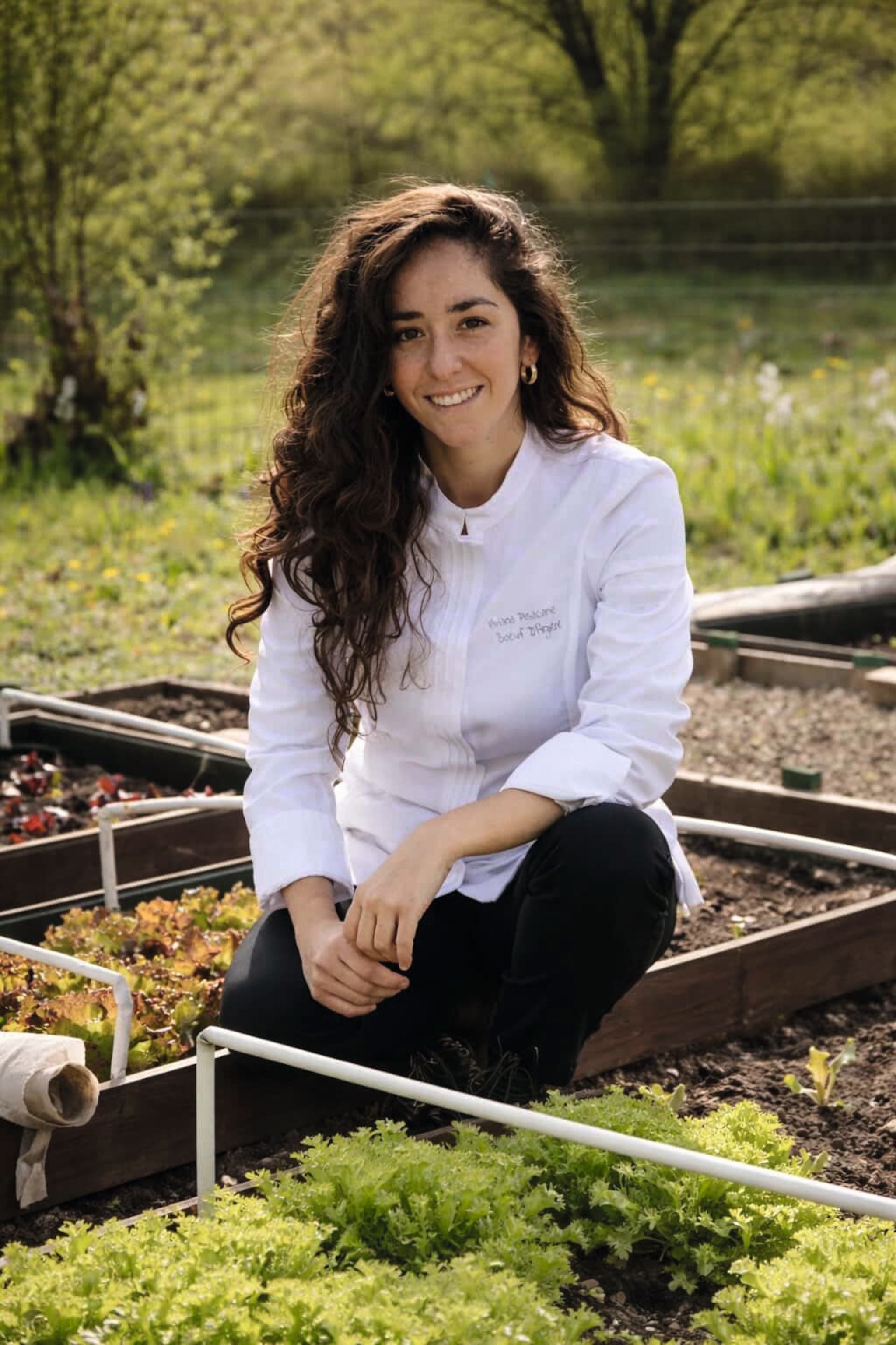 Chef sat outdoors with curly hair down