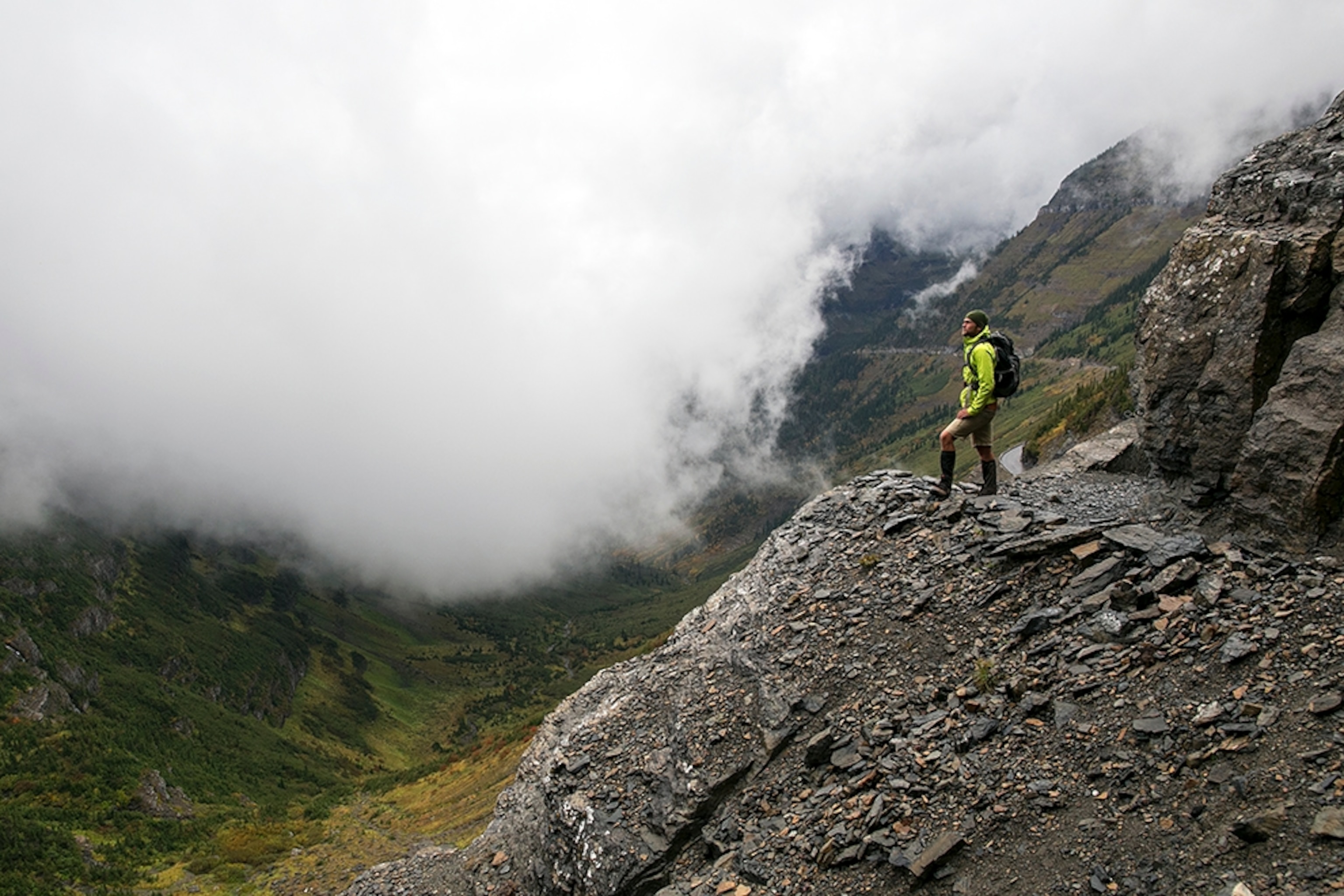 a man standing at an overlook on the Highline Trail in Glacier National Park, Montana