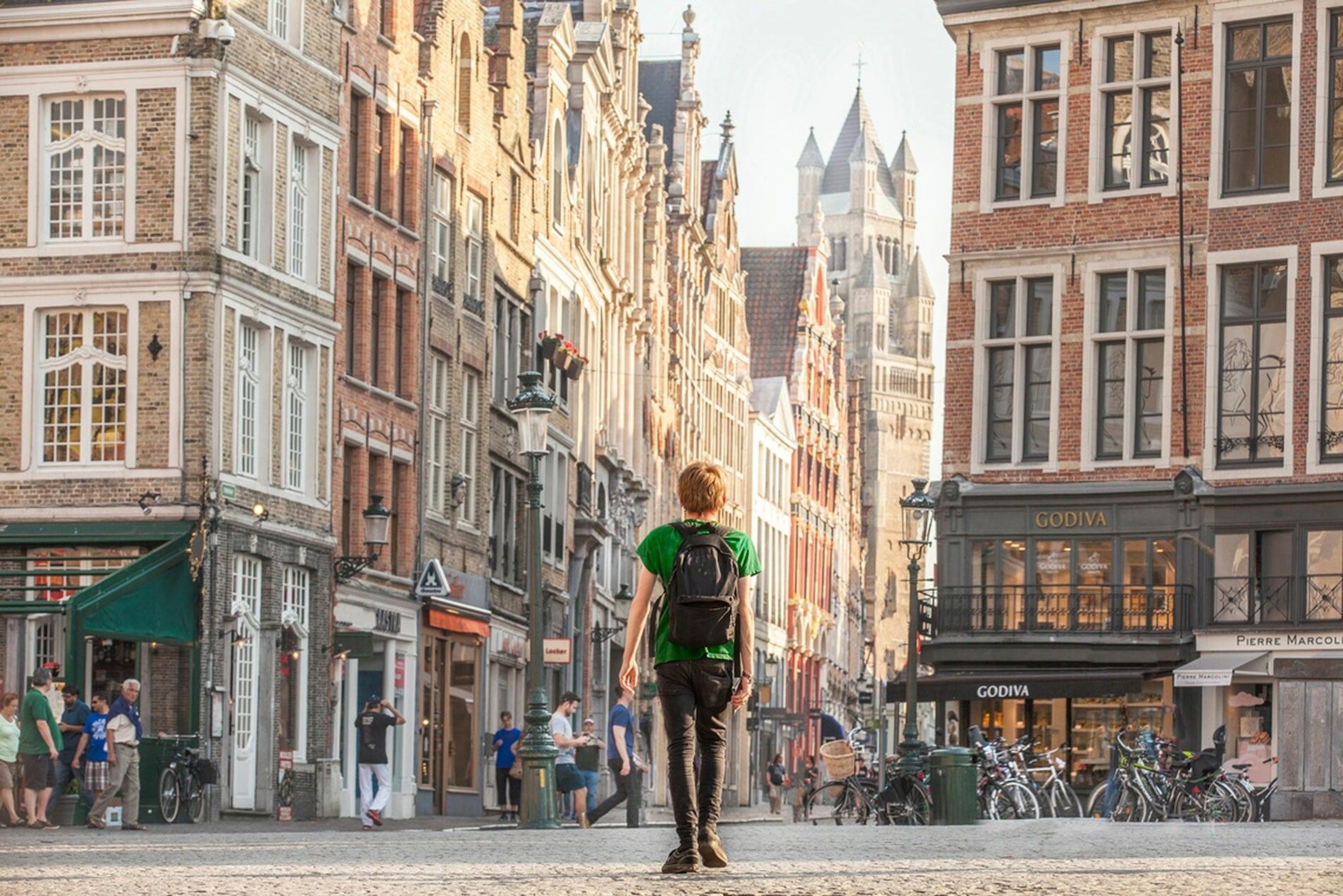 A town square with shops. A person walks across it.