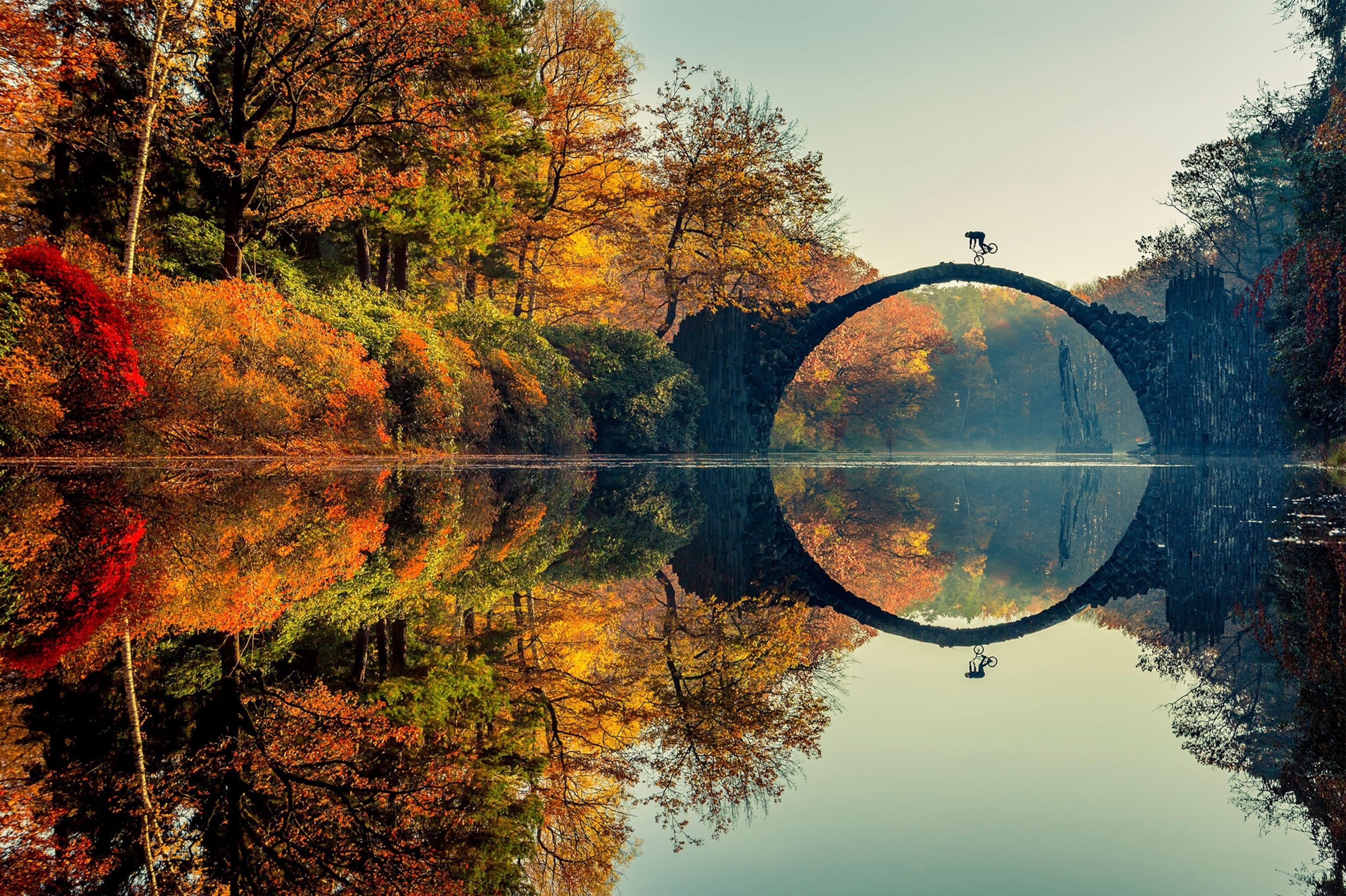 a biker pulling a trick over a stone bridge in Germany