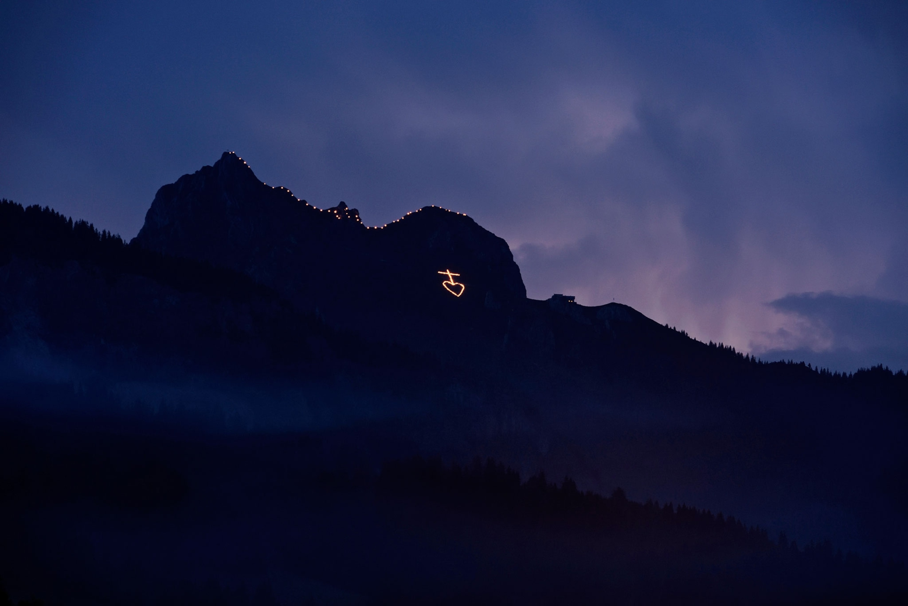 fires on a mountainside to acknowledge Sacred Heart of Jesus fires