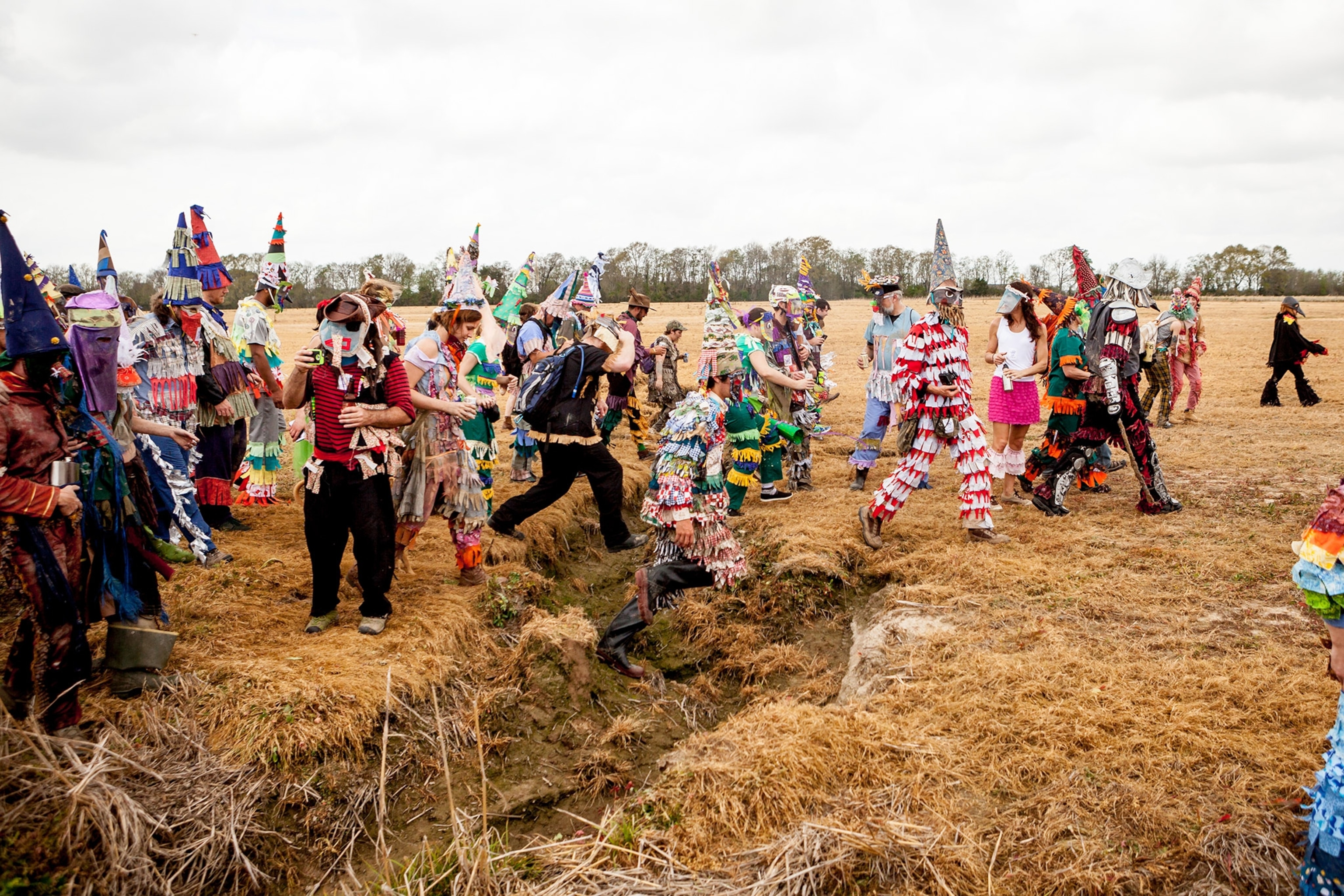 participants walking through a field at the Courir de Mardi Gras celebration