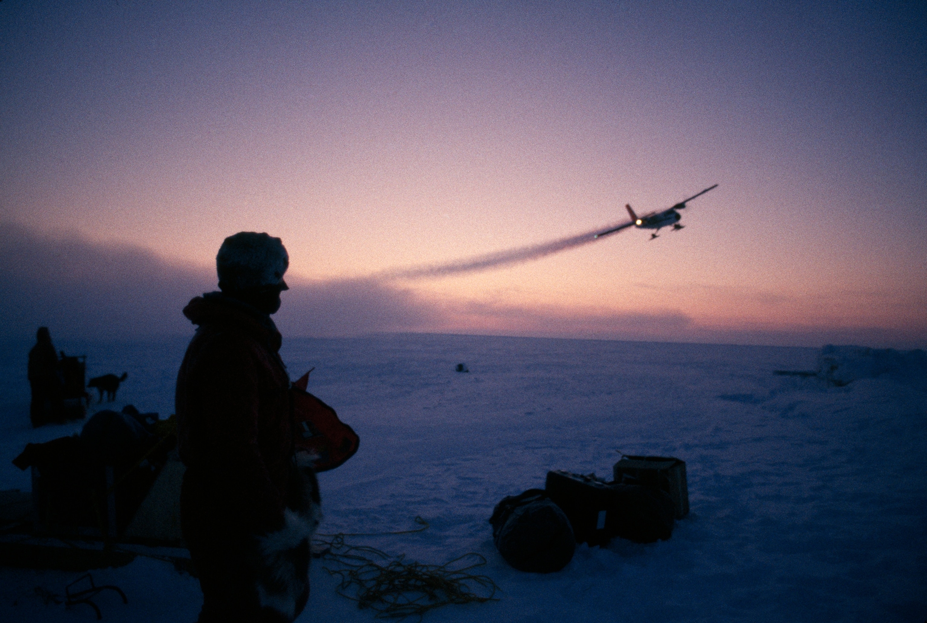 An expedition to the North Pole watches their drop-off plane depart.
