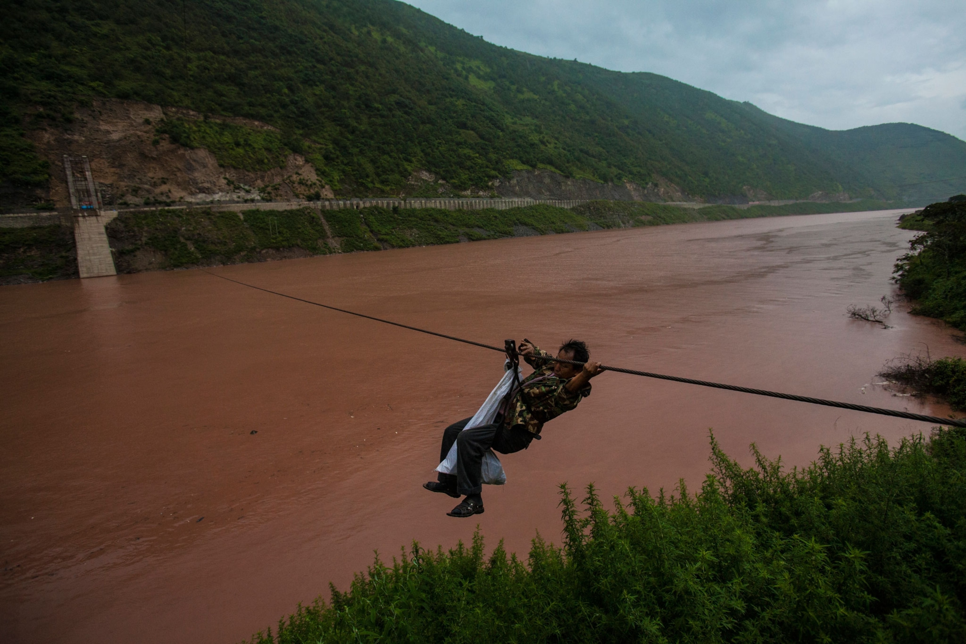A man crosses the Mekong in China with a cable.