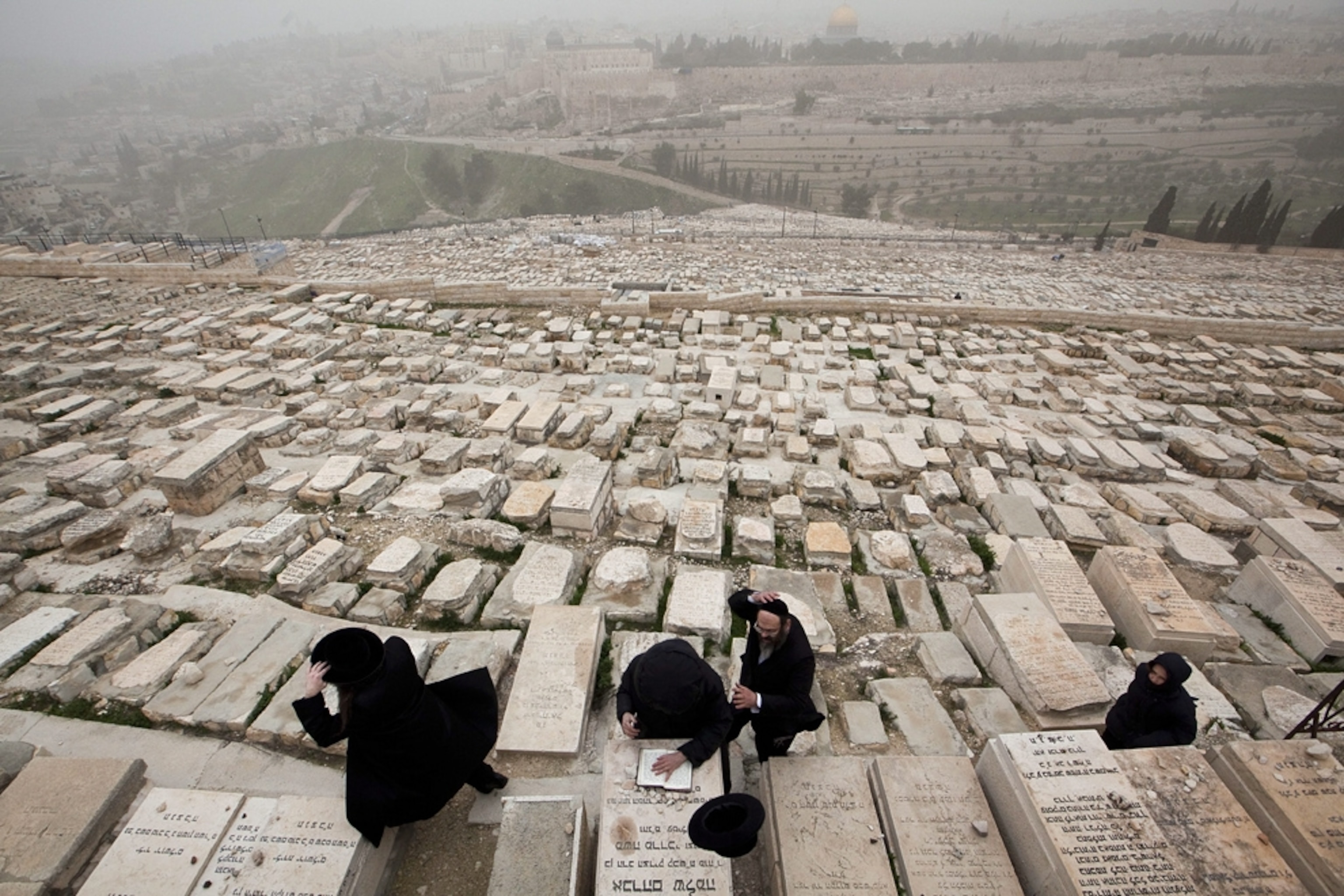 Cemetery picture: people praying in a Jewish cemetery in Jerusalem