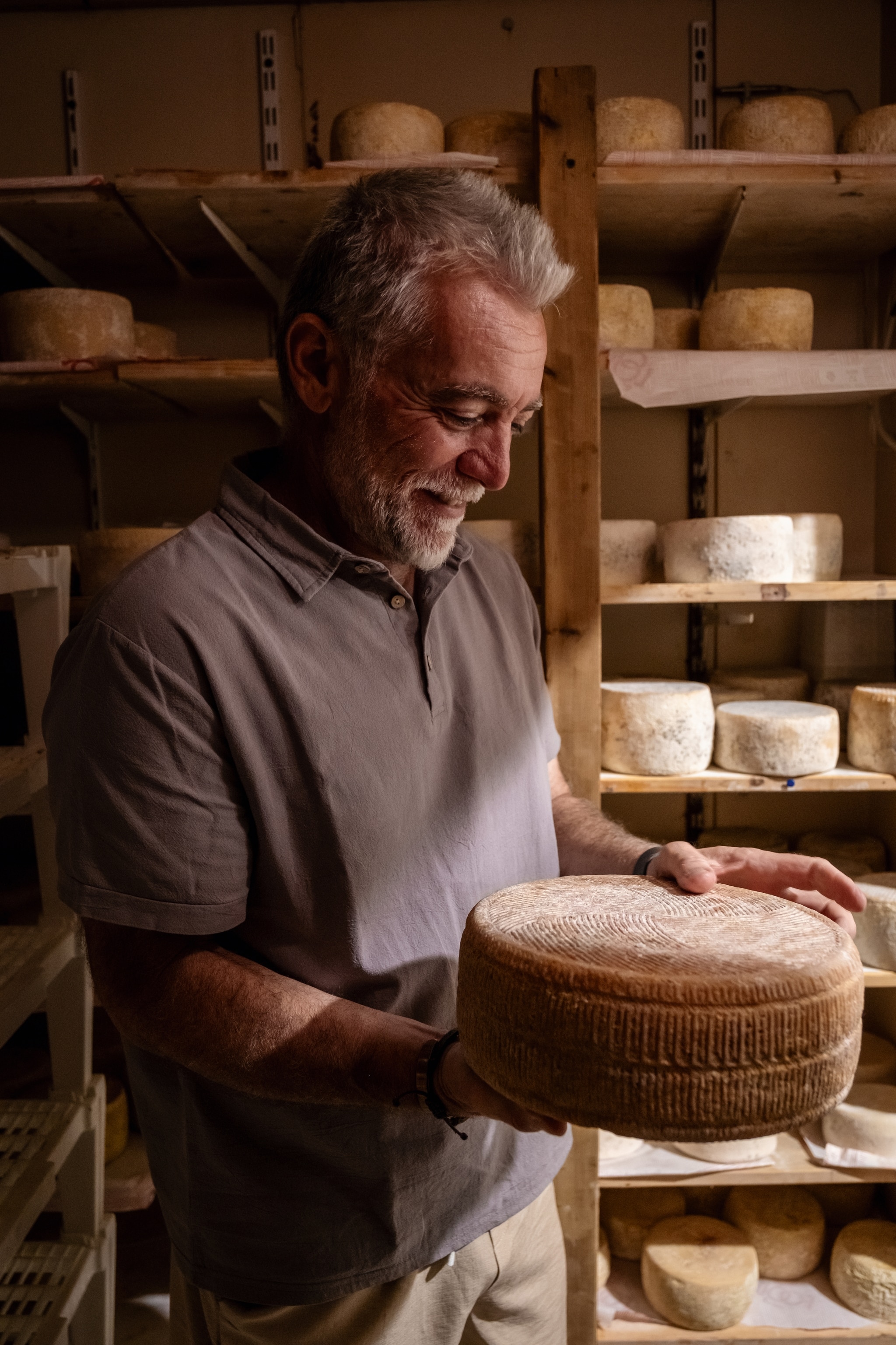 Man checks on ageing cheese wheel