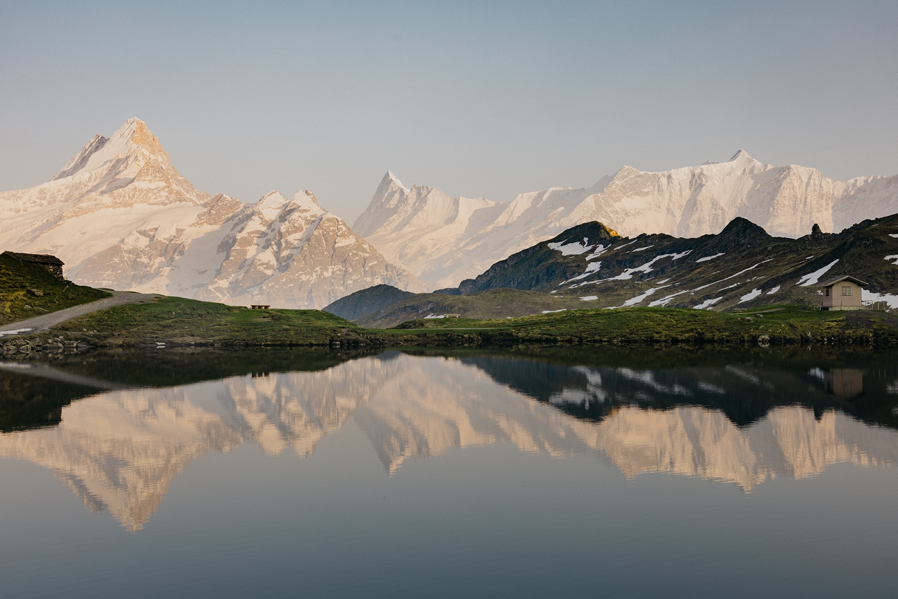 A scenic mountain lake with a valley in ridge in the background as the peaks reflect on its clear surface.