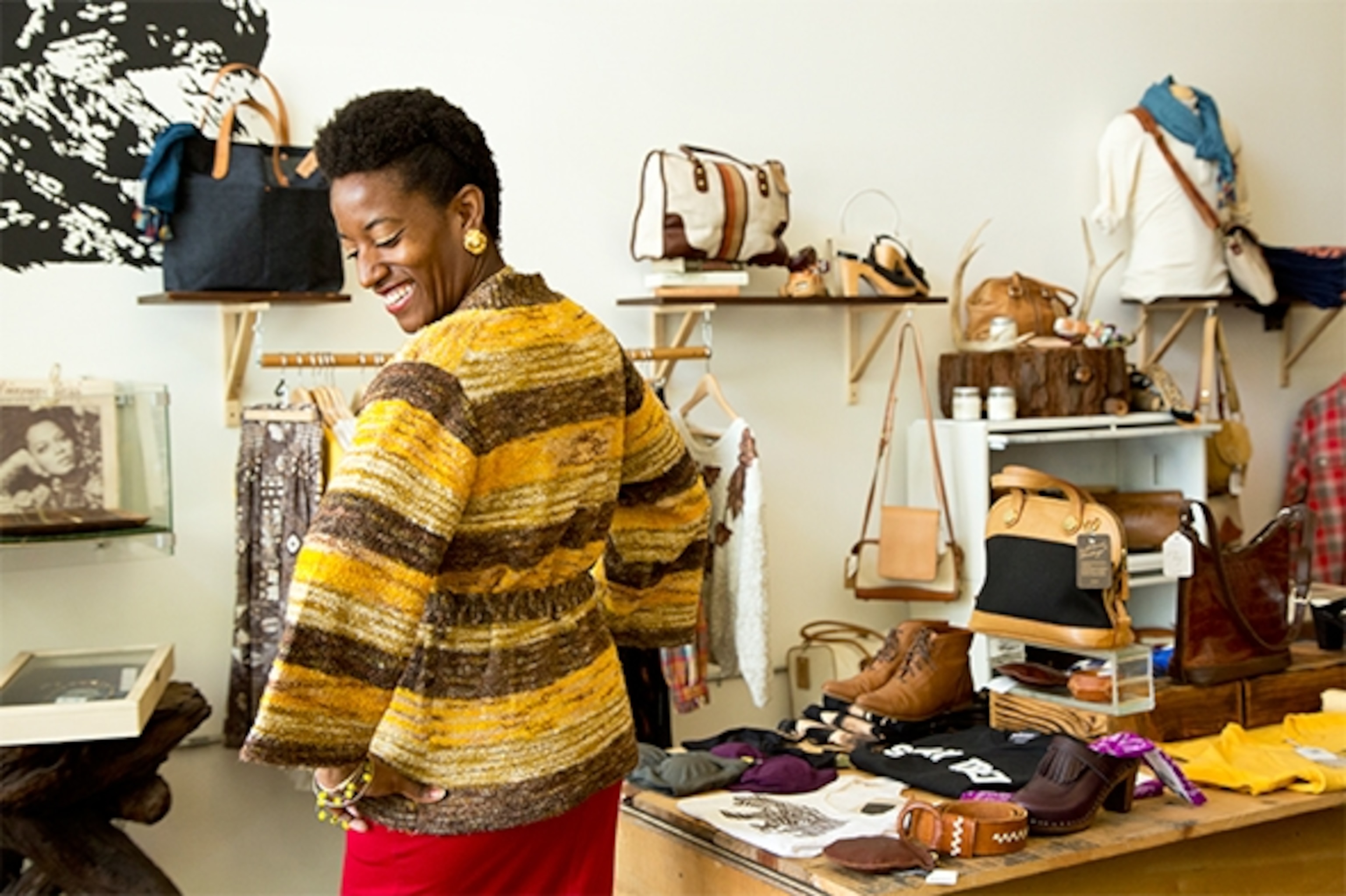 Mahogany Moton tries on a vintage sweater at Owl N Wood, a new boutique in Oakland's Uptown District.  (Photograph by Catherine Karnow)