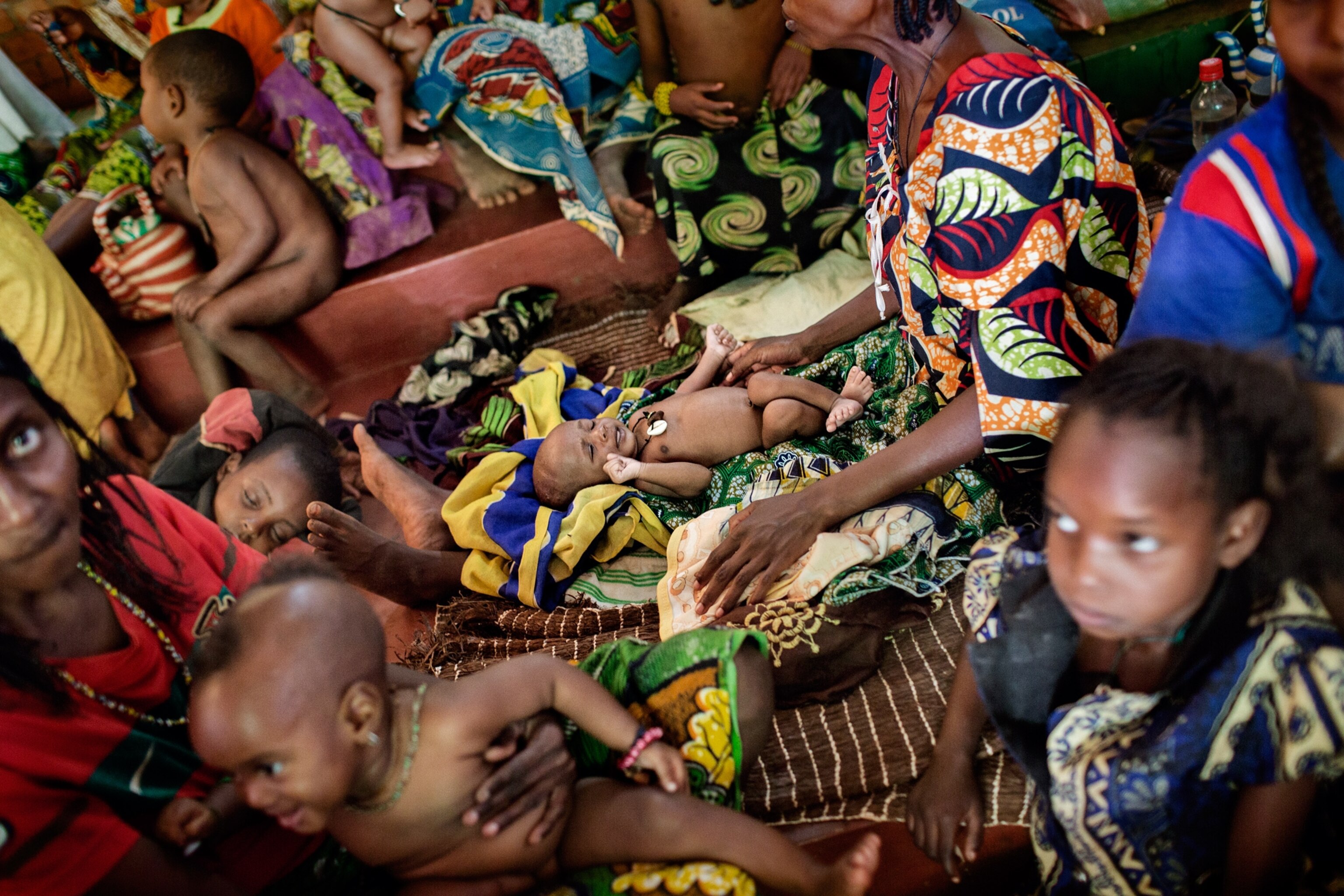 people waiting in long lines for food and water distribution.