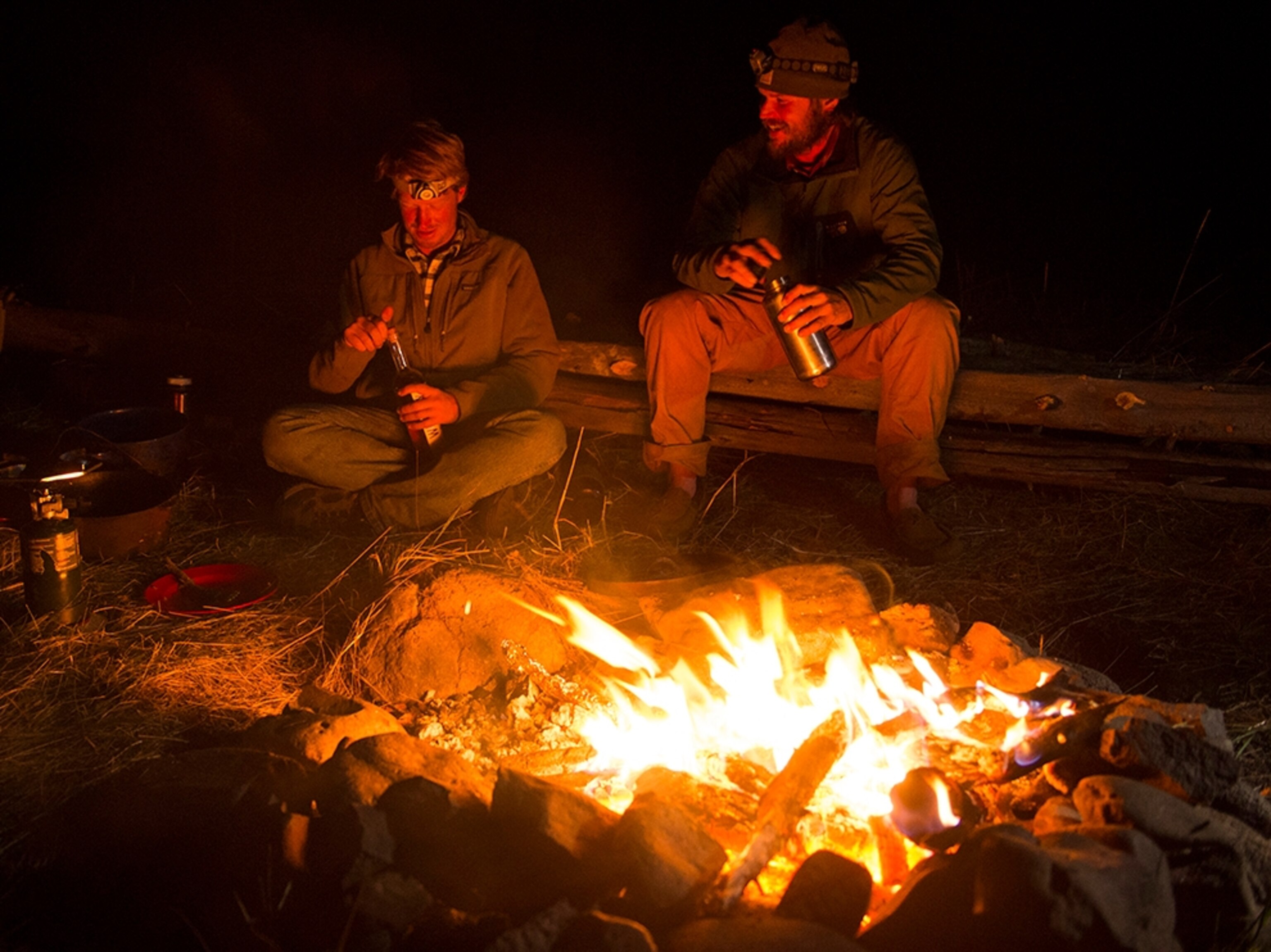 Ben Masters and Ray Knell chatting by the fire at camp along the Lamar River in Yellowstone National Park.
