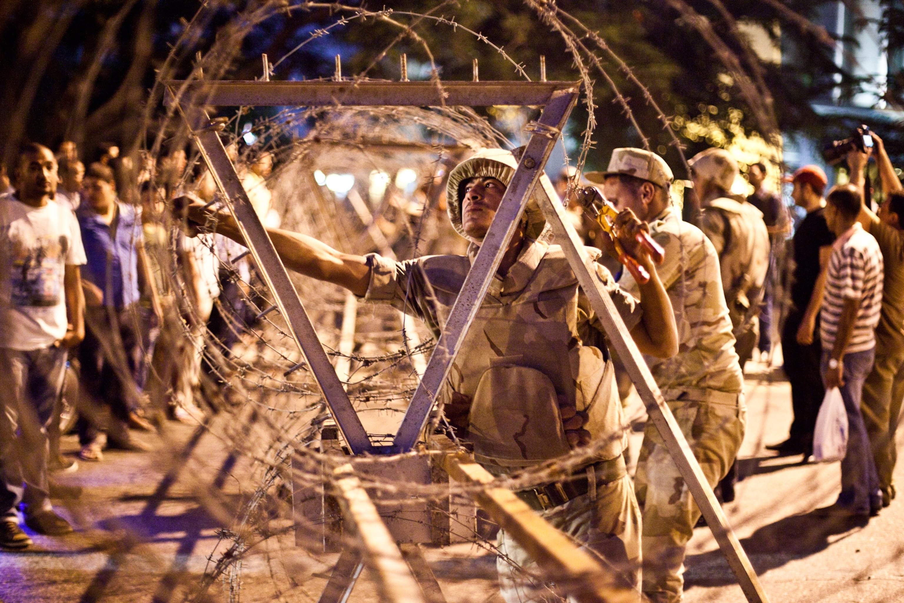 Egyptian soldiers adjust barbed wire around the Supreme Constitutional Court.