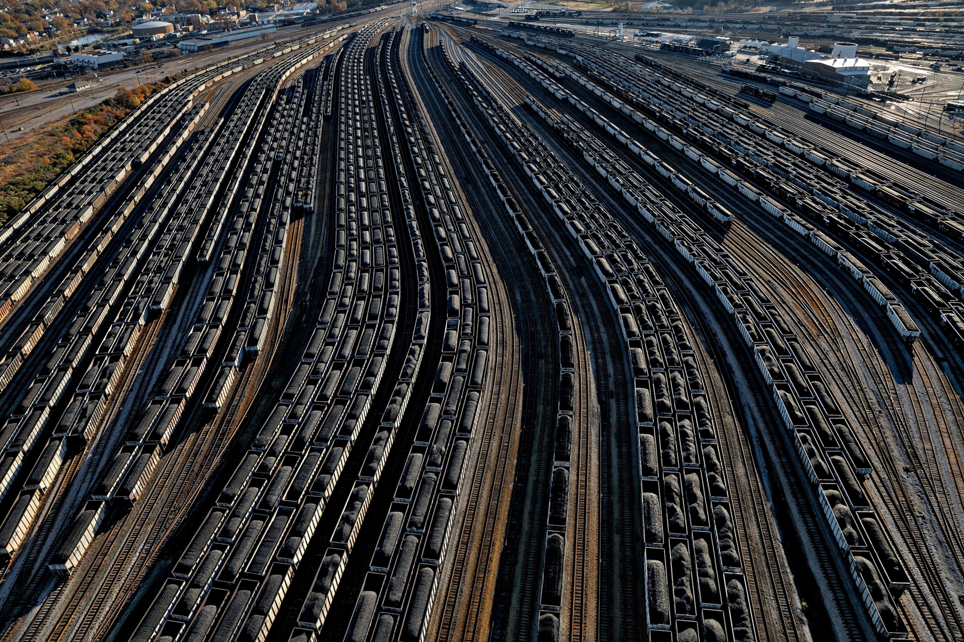 railcars loaded with coal line up to fill waiting ships