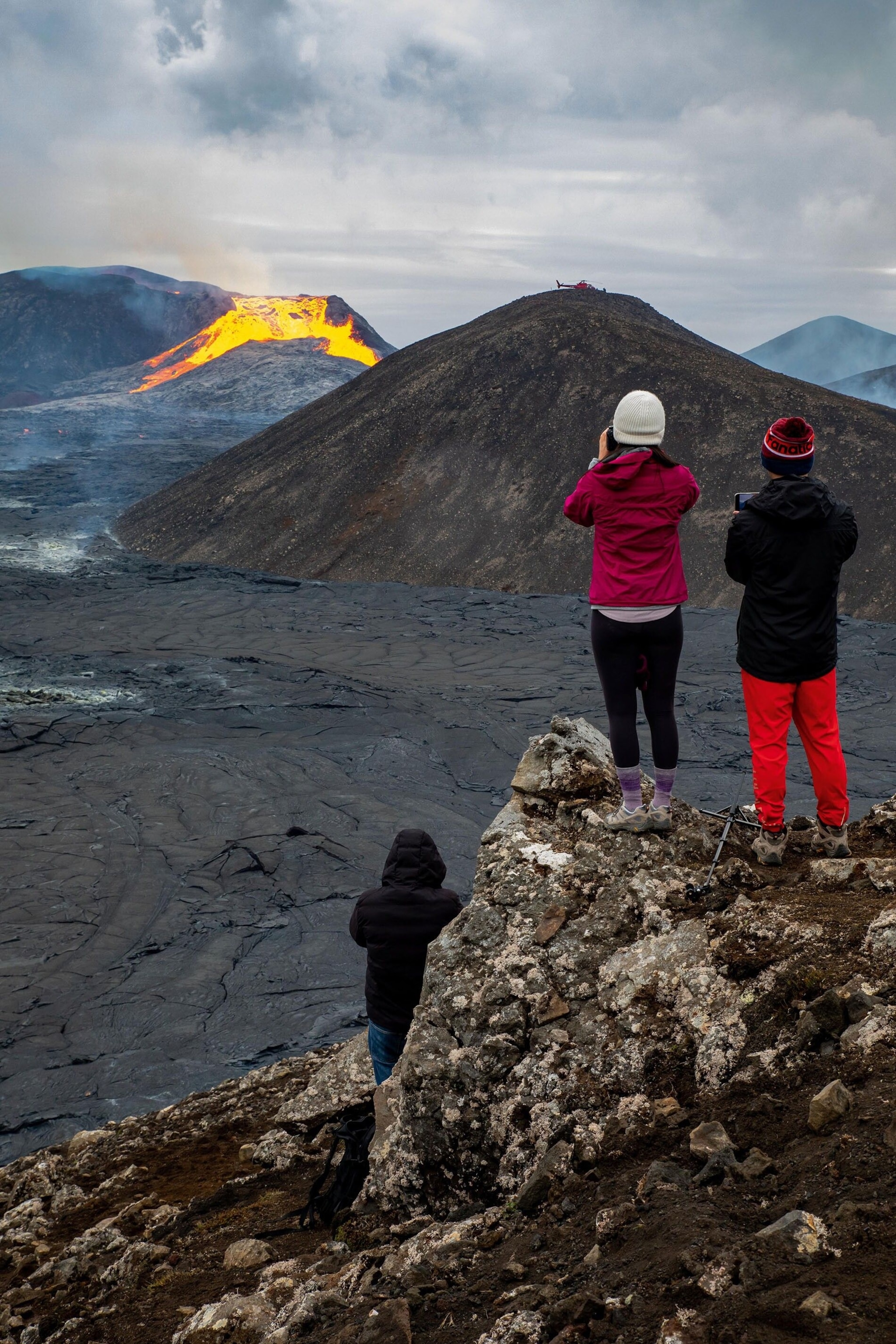 Travellers watch the lava flow from Fagradalsfjall, which started erupting in March of 2021.