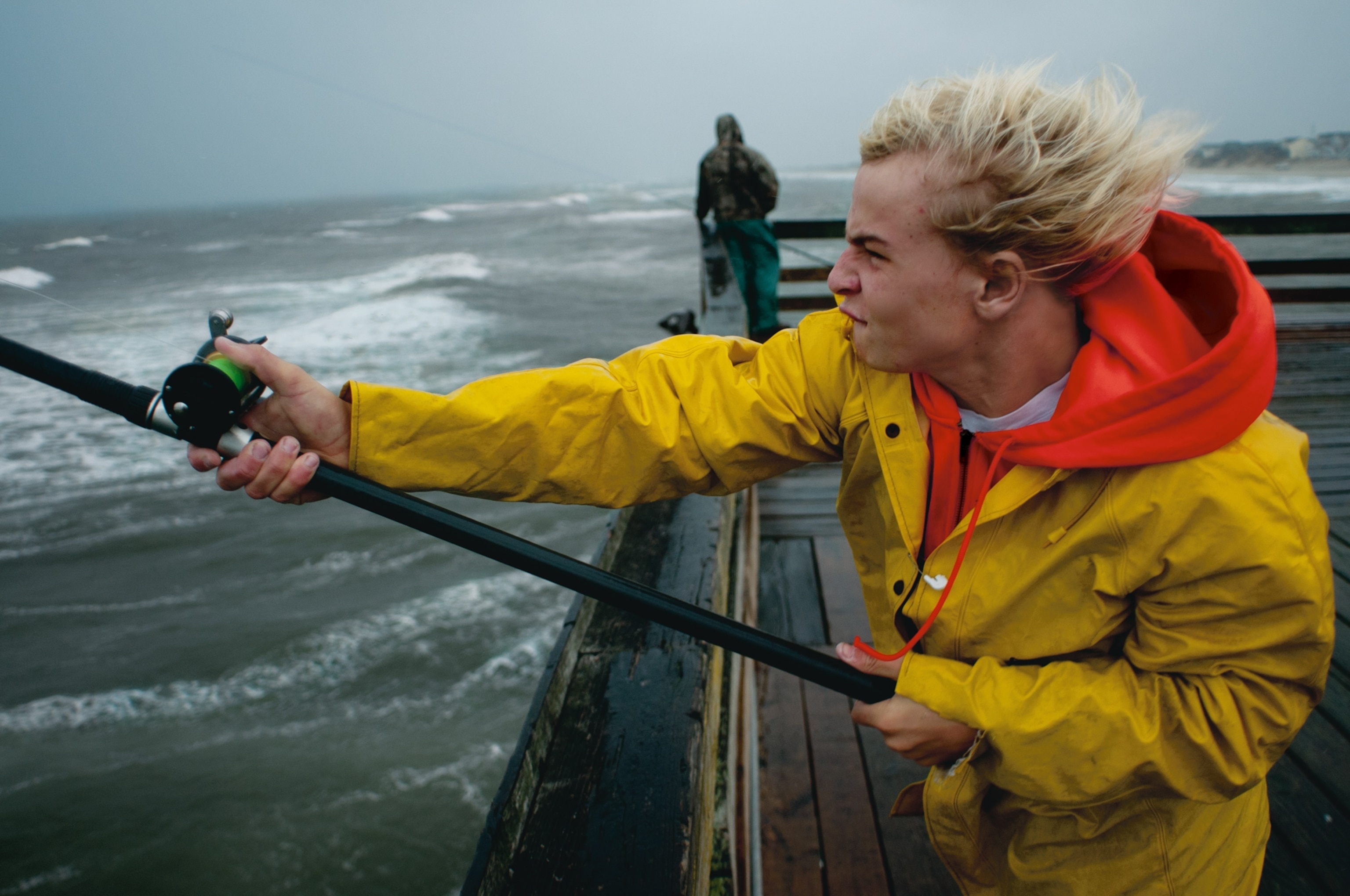 a boy fishing from the Nags Head Pier during a nor'easter
