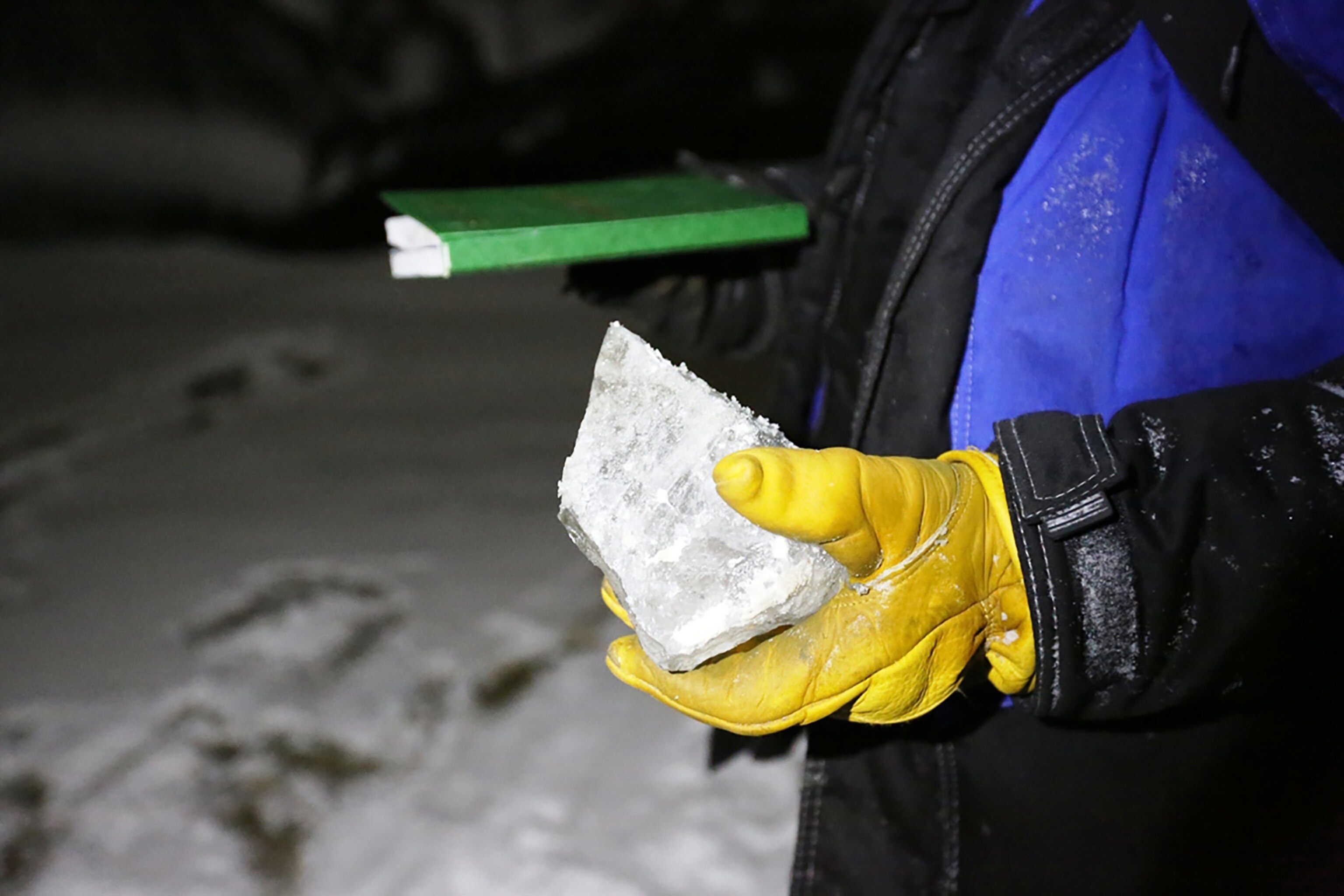 a scientist examining a piece of ice from the bottom of the Yamal crater.