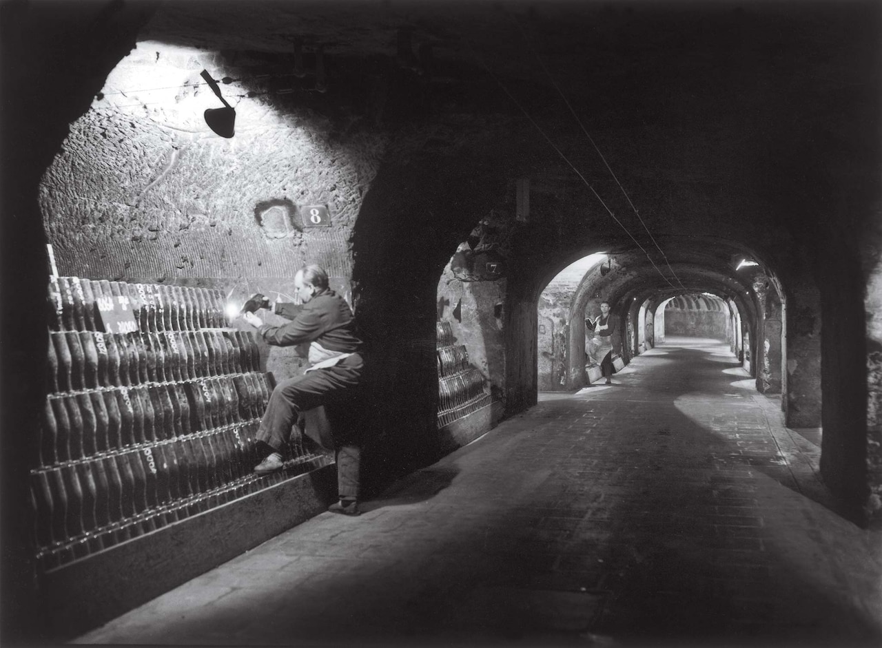 A worker removes sediment from bottles of Champagne in the cellars of Moët & Chandon in 1961.