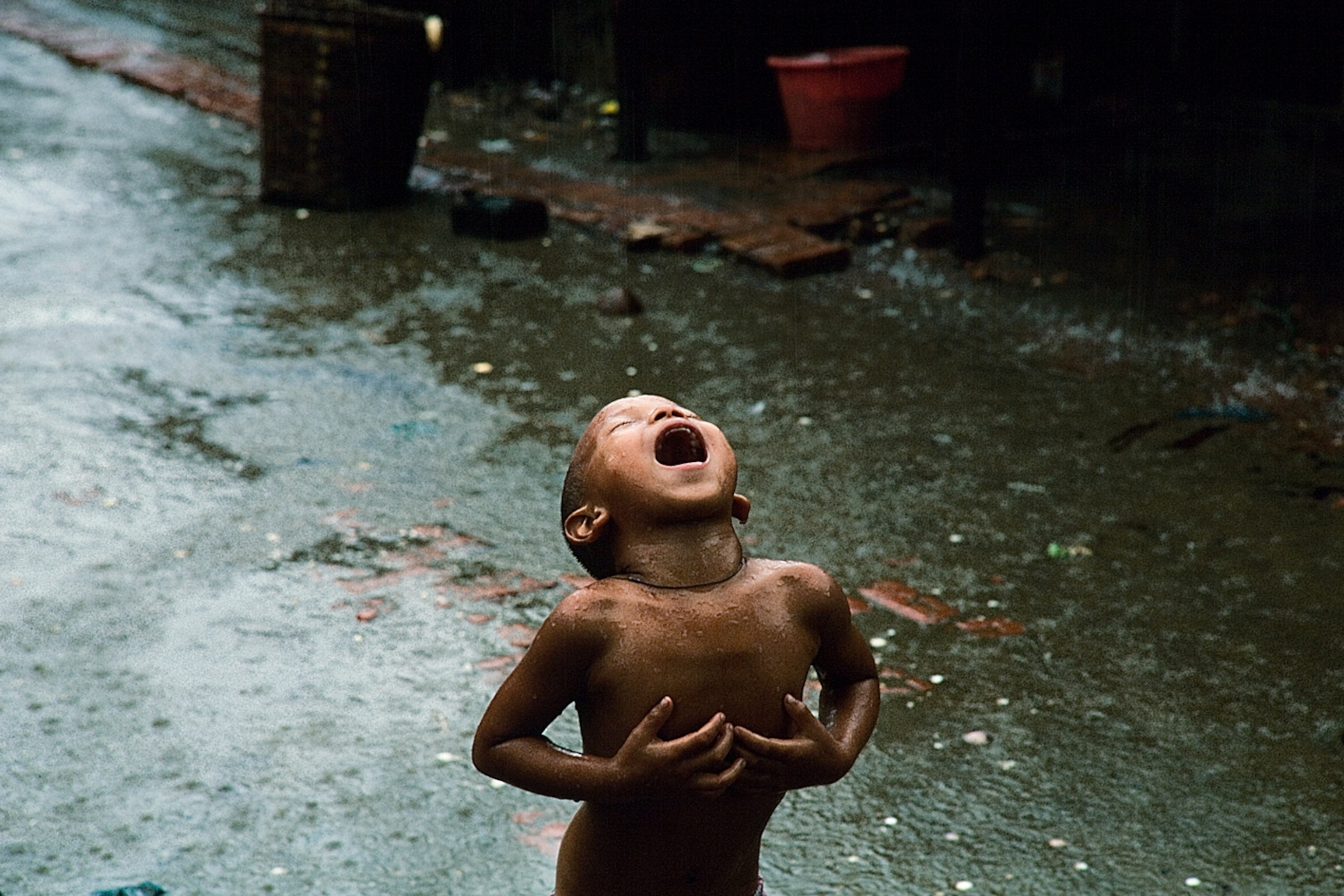 a young girl in the village of Eya drinking in the monsoon rains
