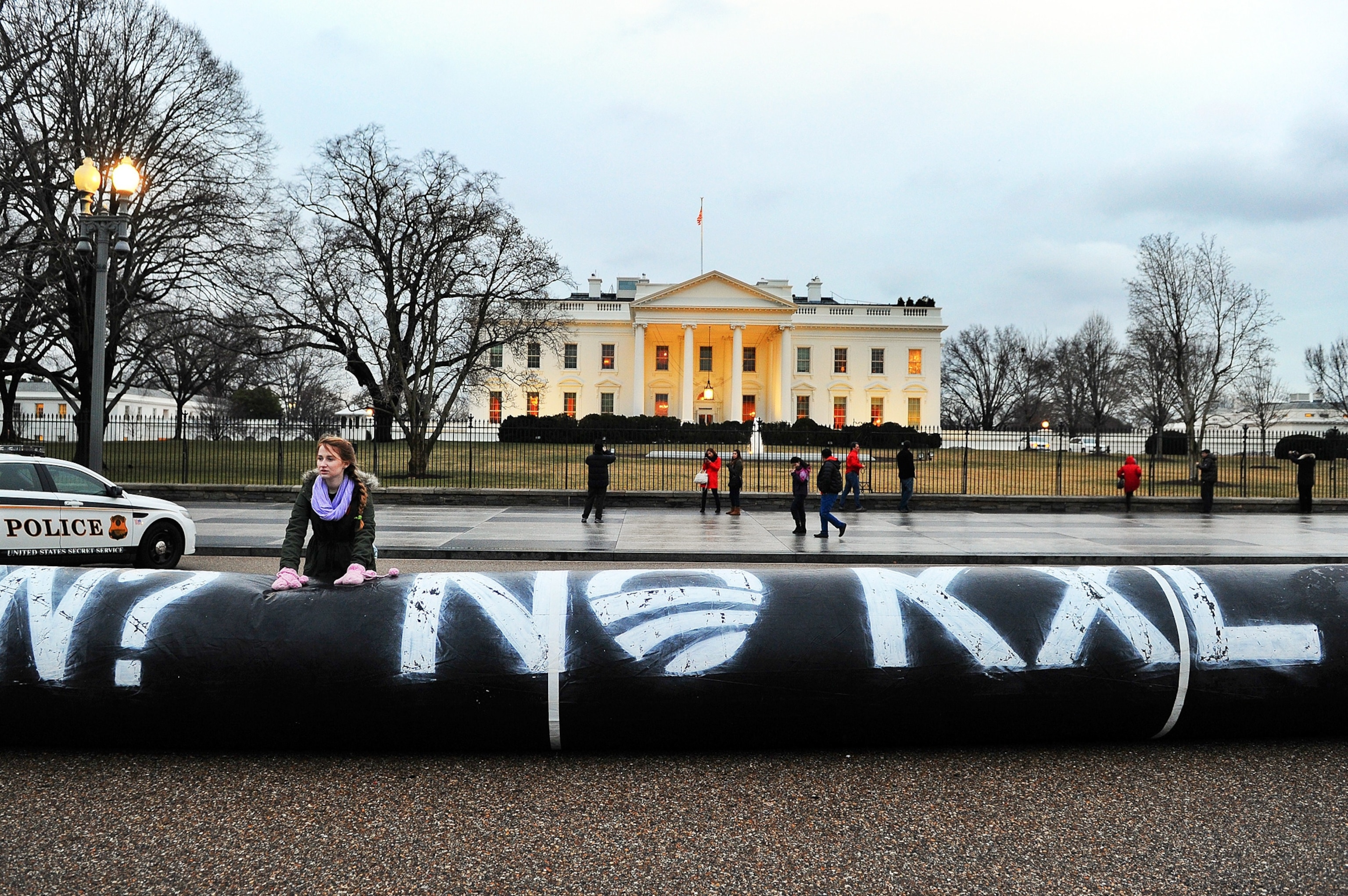 Environmental activists inflate a long balloon to mock a pipeline during a demonstration in front of the White House in Washington, DC.