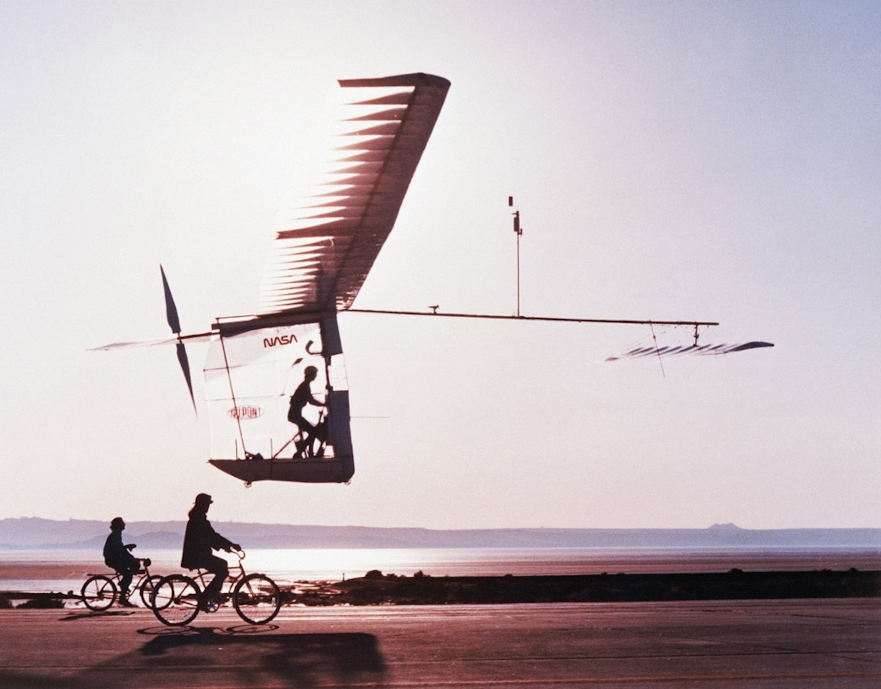 Two cyclists and an experimental Gossamer Albatross aircraft
