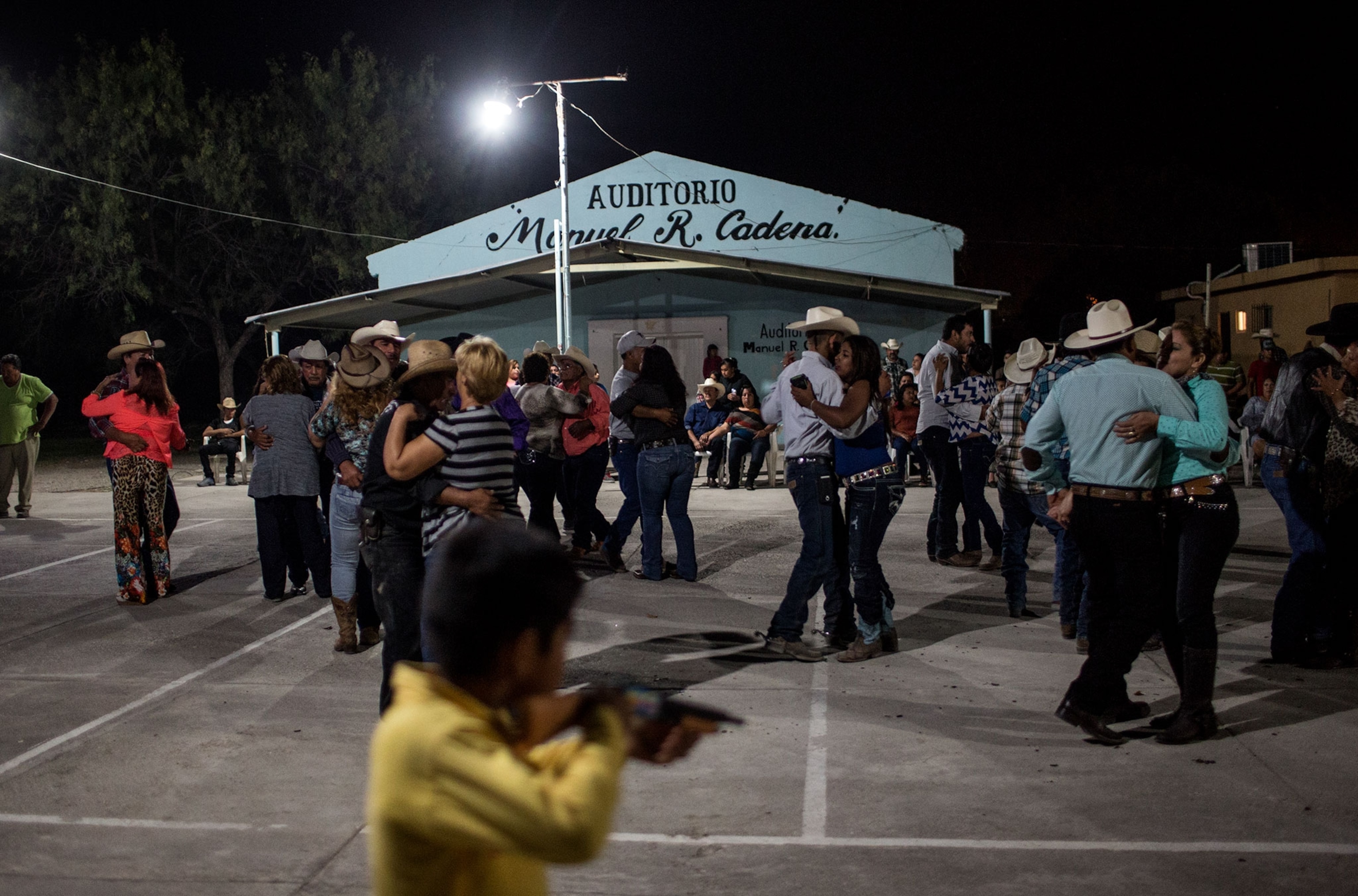 a boy playing with a toy gun during a dance in Mexico