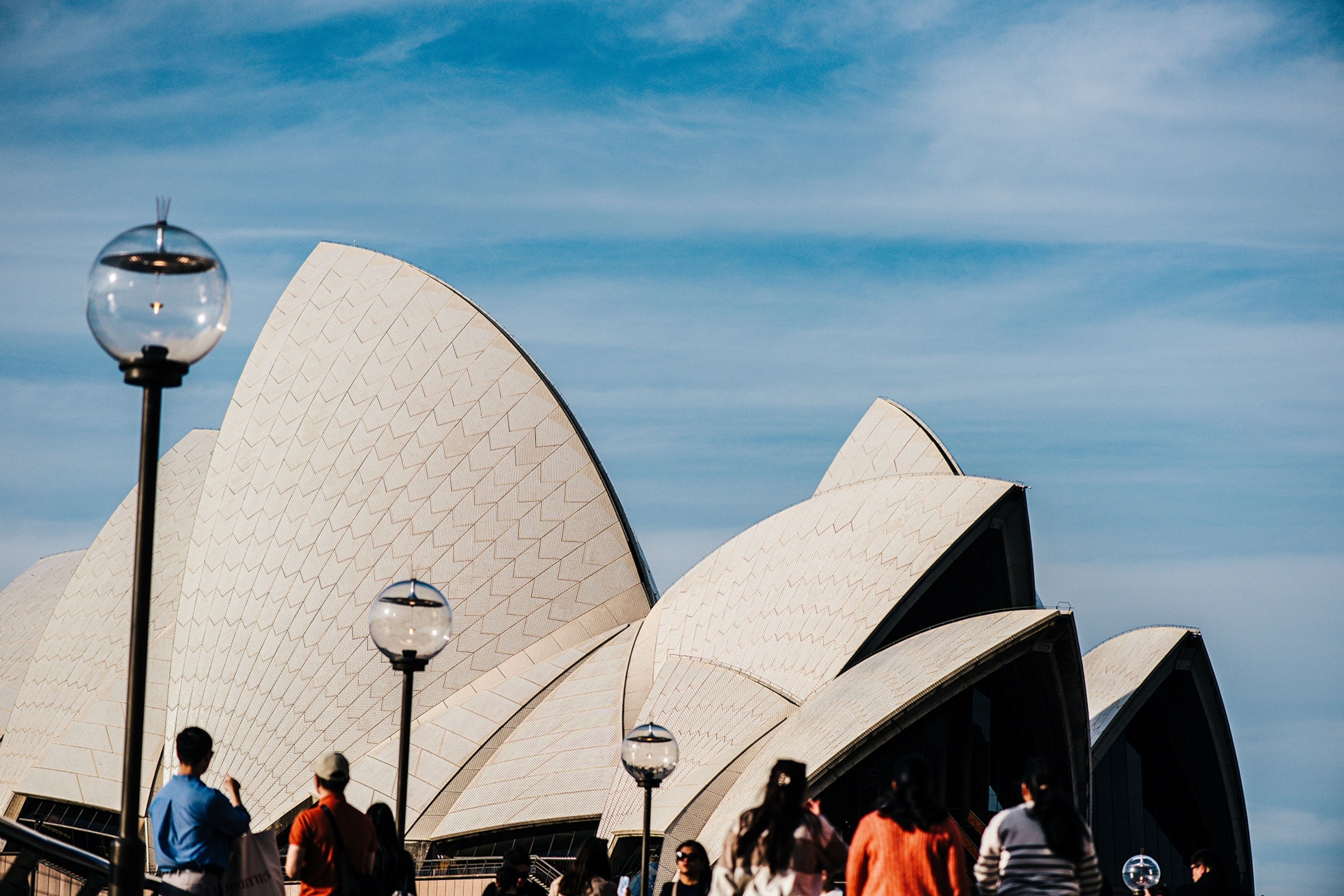 The exterior of an opera house by the sea, looking like stacked shells.