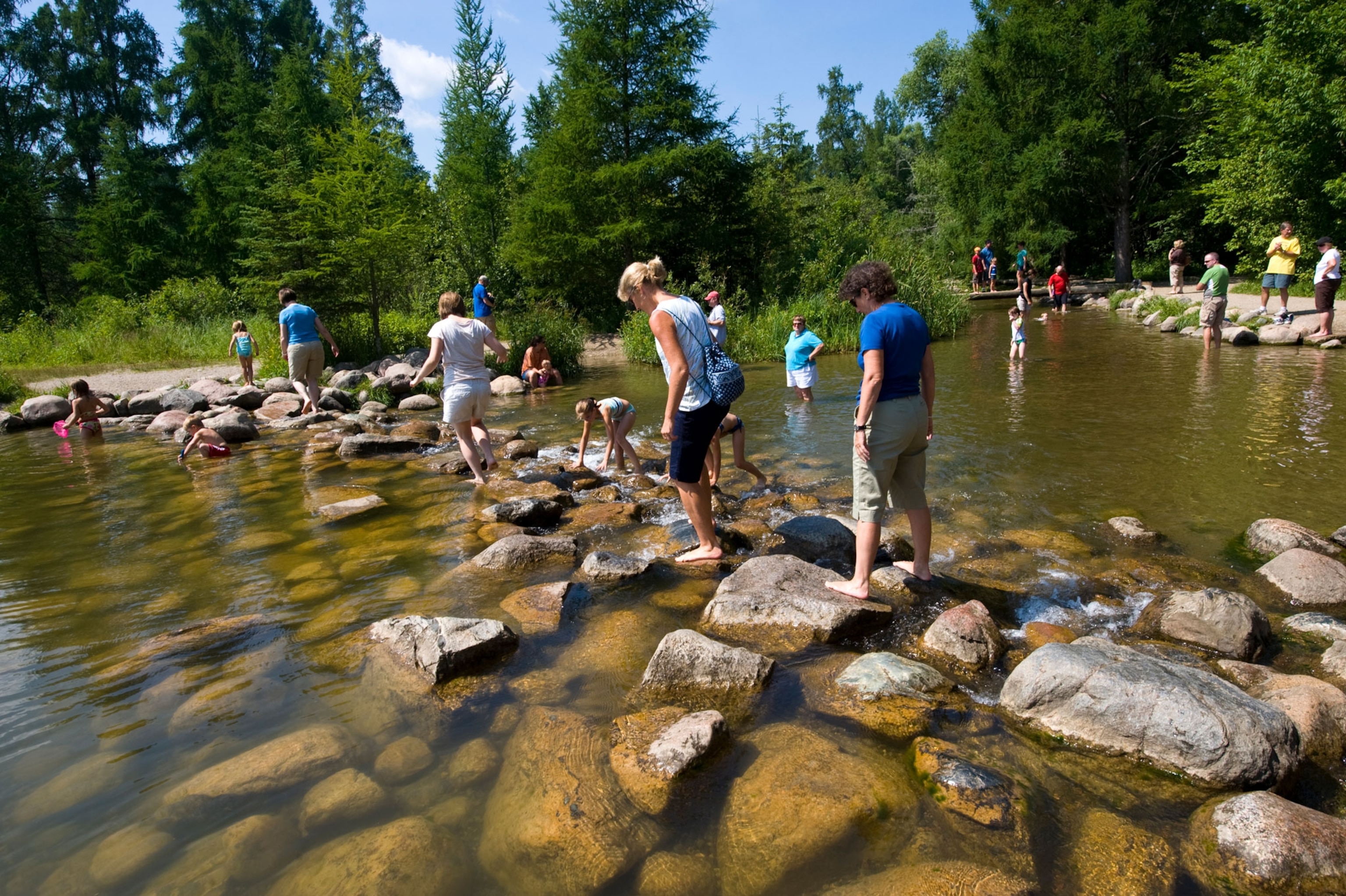 People crossing a stone bridge on a river