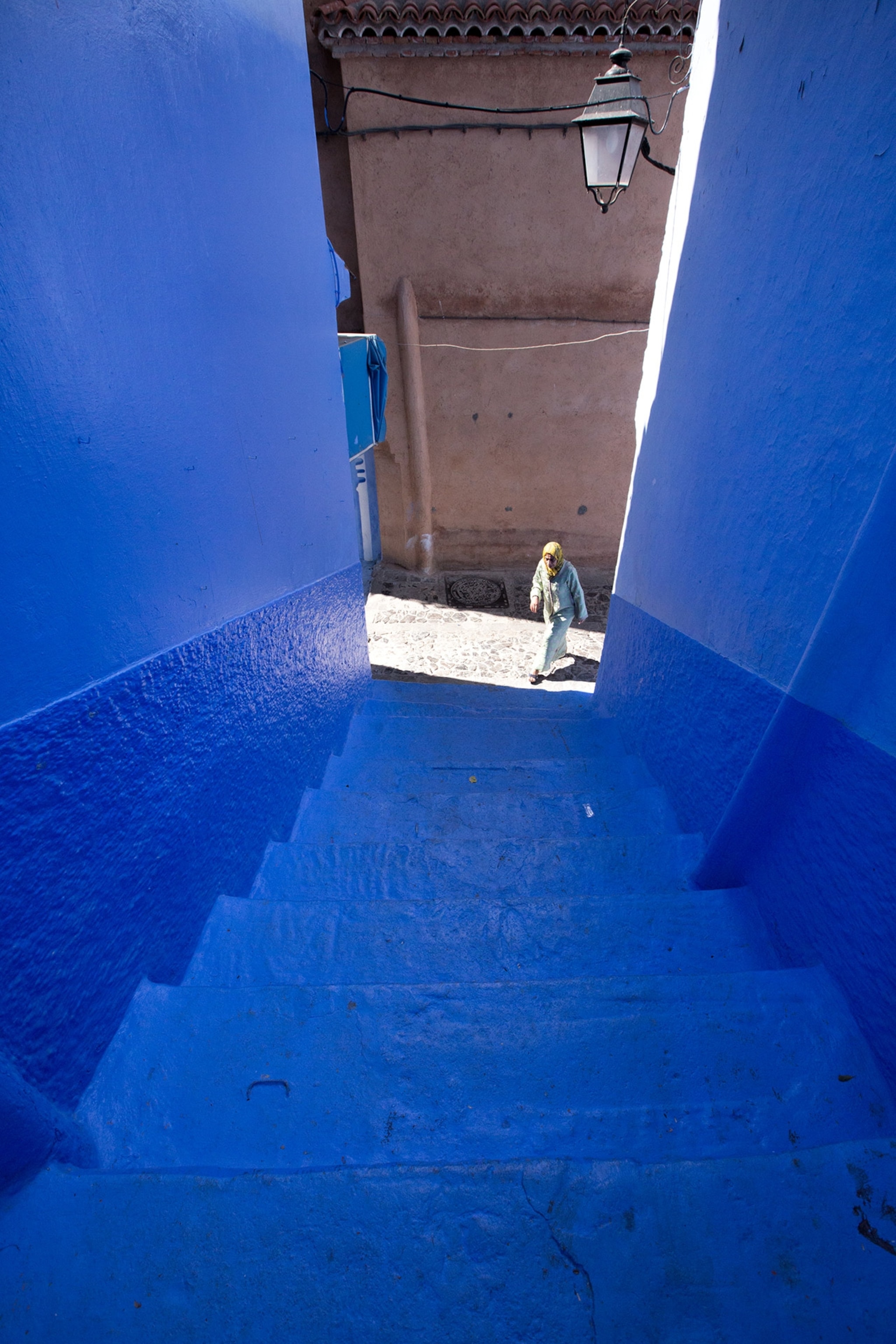 a woman entering an alley in Chefchaouen, Morocco's Blue City