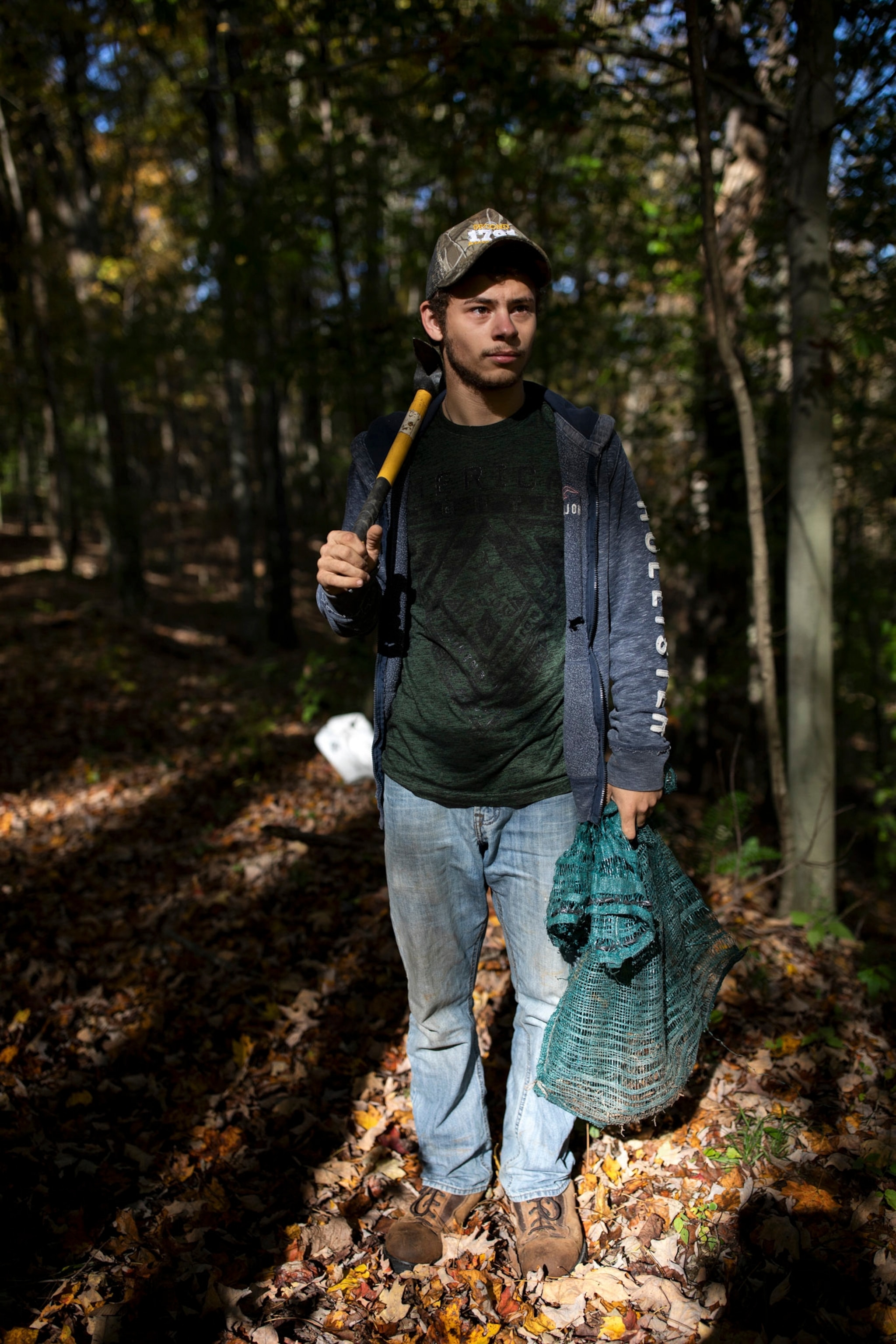 a man stands in the woods with digging equipment in West Virginia