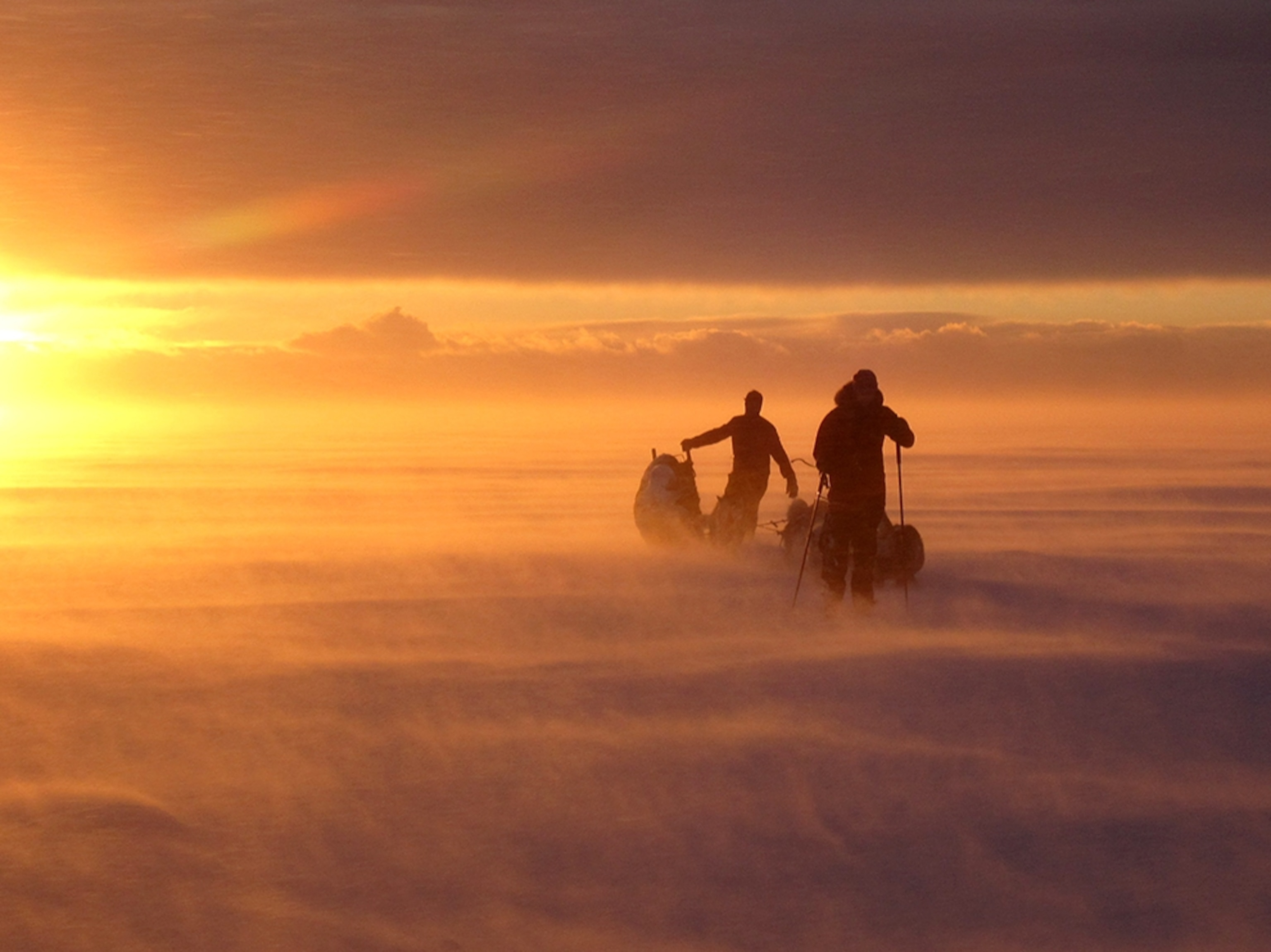 Amy and Dave Freeman skiing with their dog team on Great Bear Lake, Northwest Territories, Canada