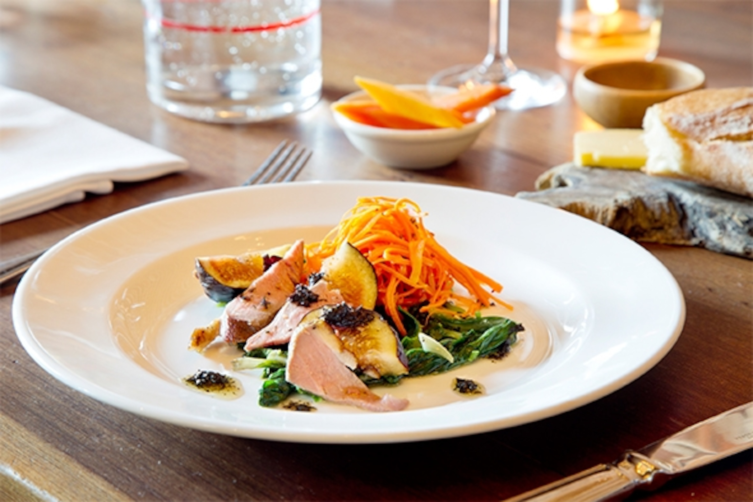 Upscale Camino restaurant, whose chef and co-owner Russell Moore cooked at Chez Panisse for more than 20 years, is known for its rustic, ingredient-focused dishes, such as the smoked duck breast and fig salad with carrots, greens, and pounded shiso. (Photograph by Catherine Karnow)