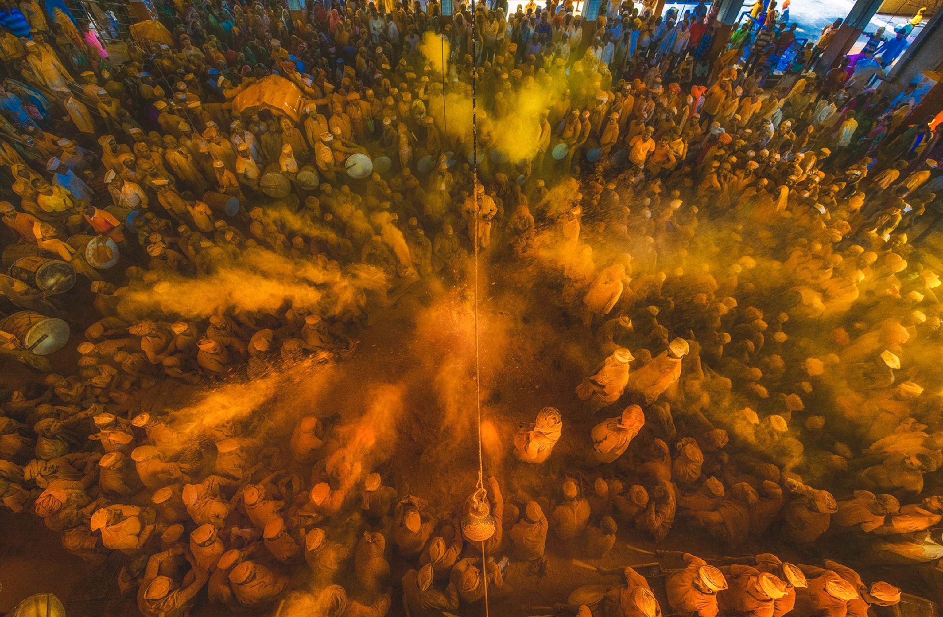 people covered in orange and yellow powder