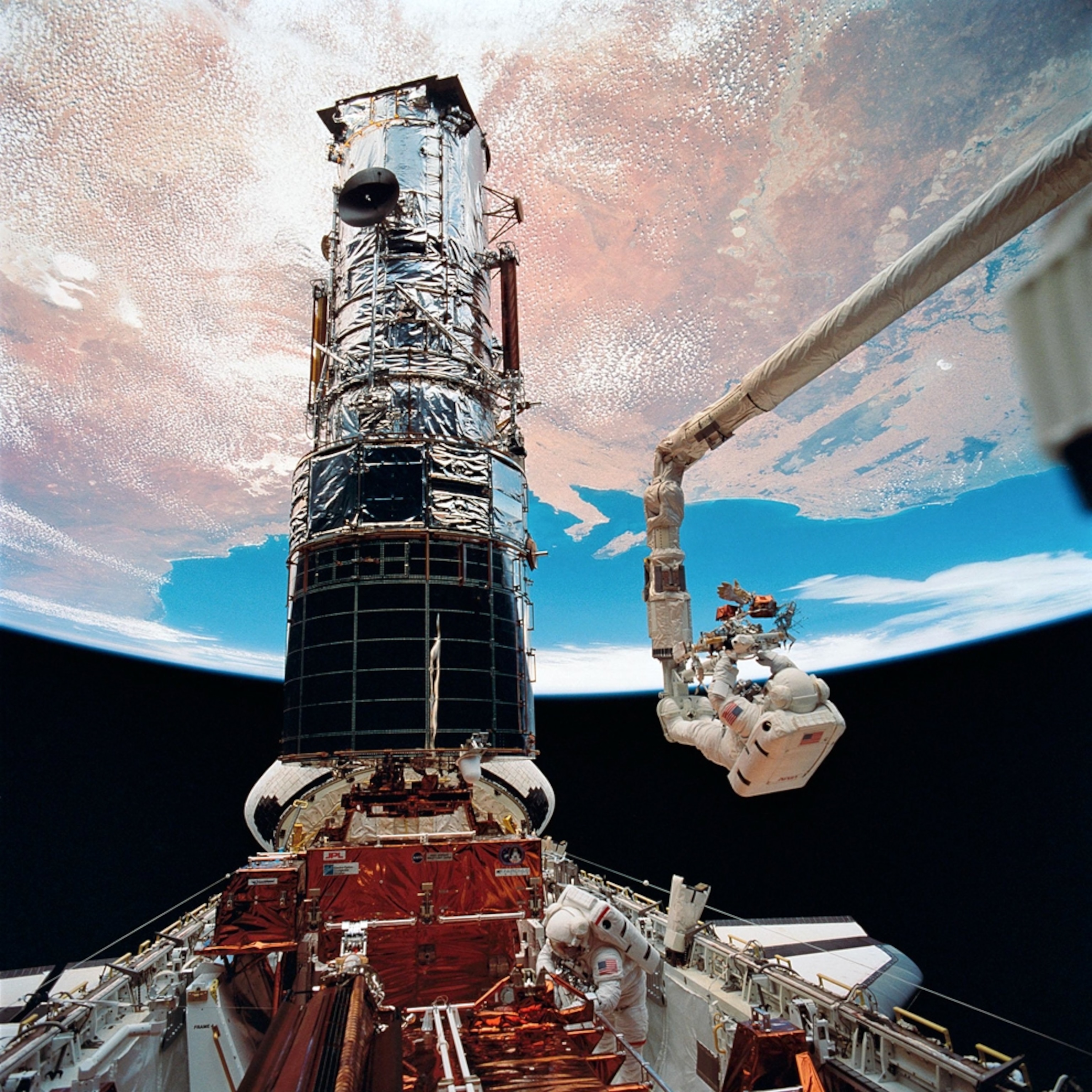 An astronaut repairs the Hubble telescope in orbit--one of the Hubble telescope's top images, according to NASA astronomers