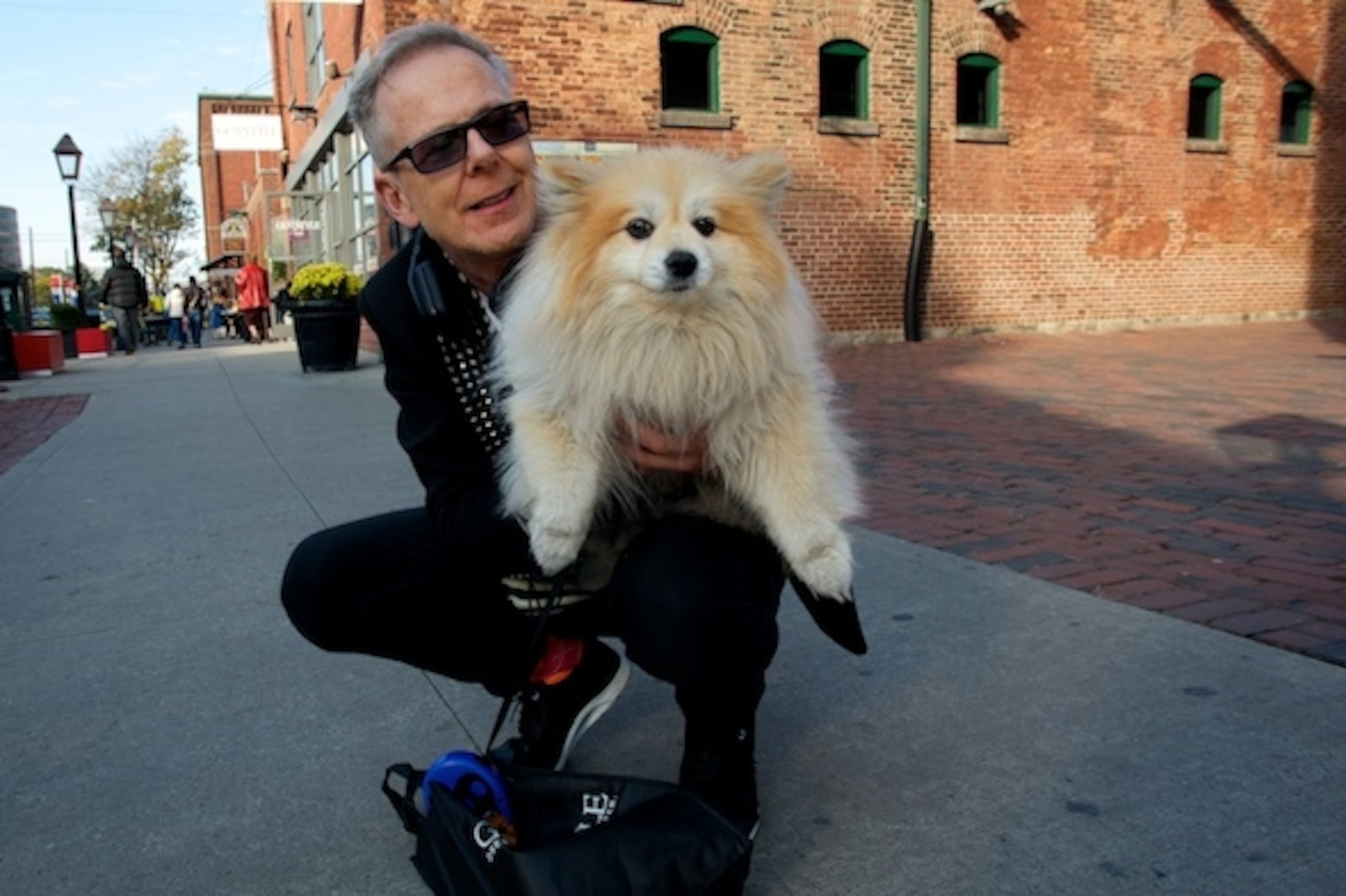 Stephen posing with his dog with the street scene unfolding behind them during "golden hour." (Photograph by Dan Westergren)
