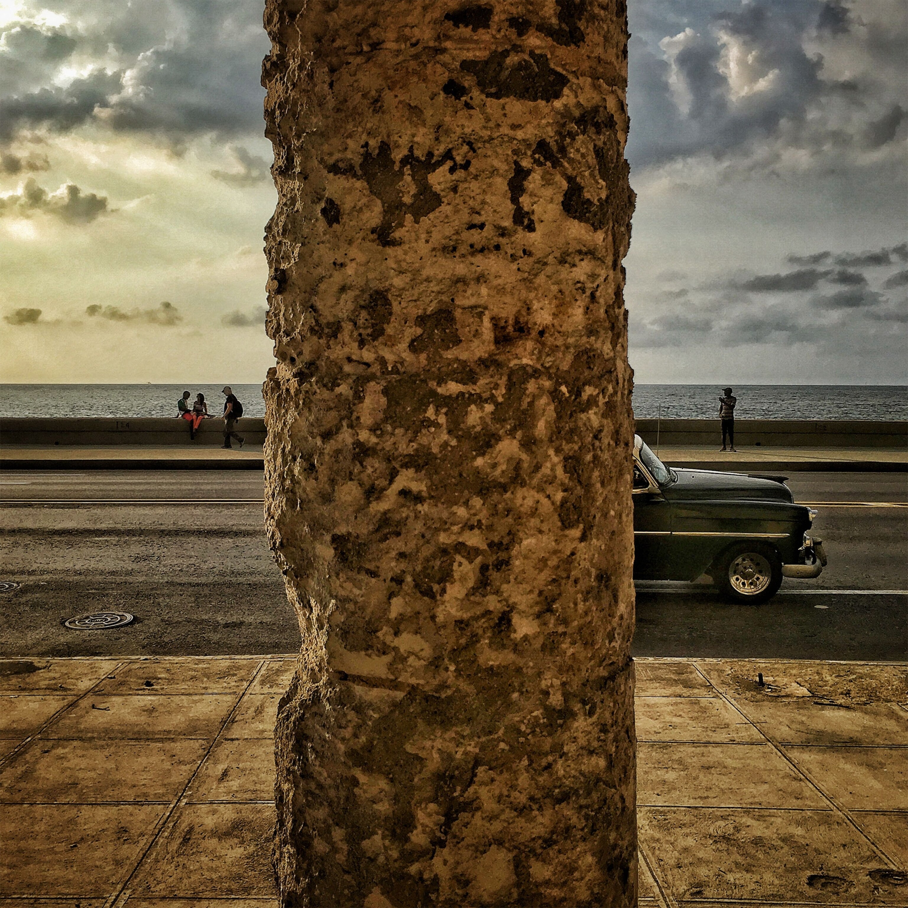 a car driving past a column in Havana, Cuba