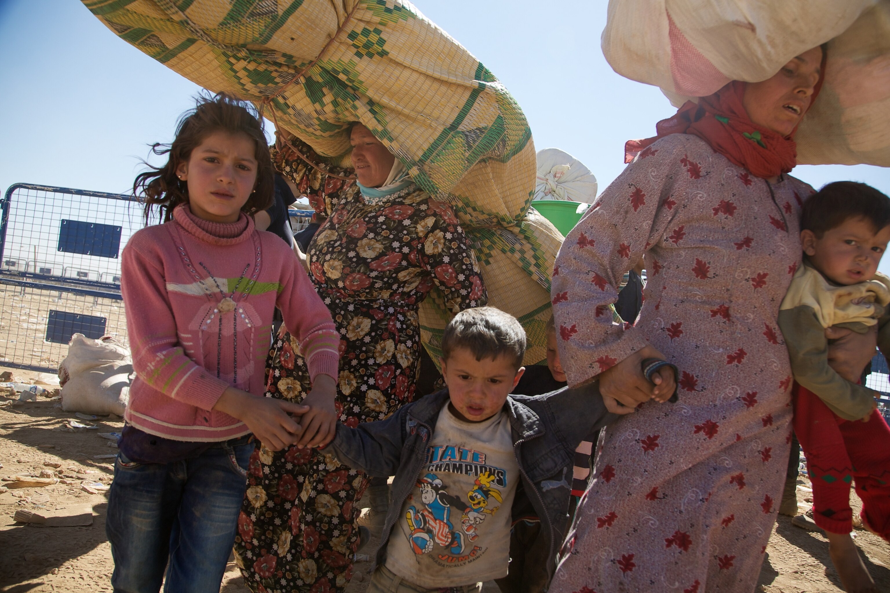 a Syrian women carrying a baby after fleeing to Turkey with thousands of others.