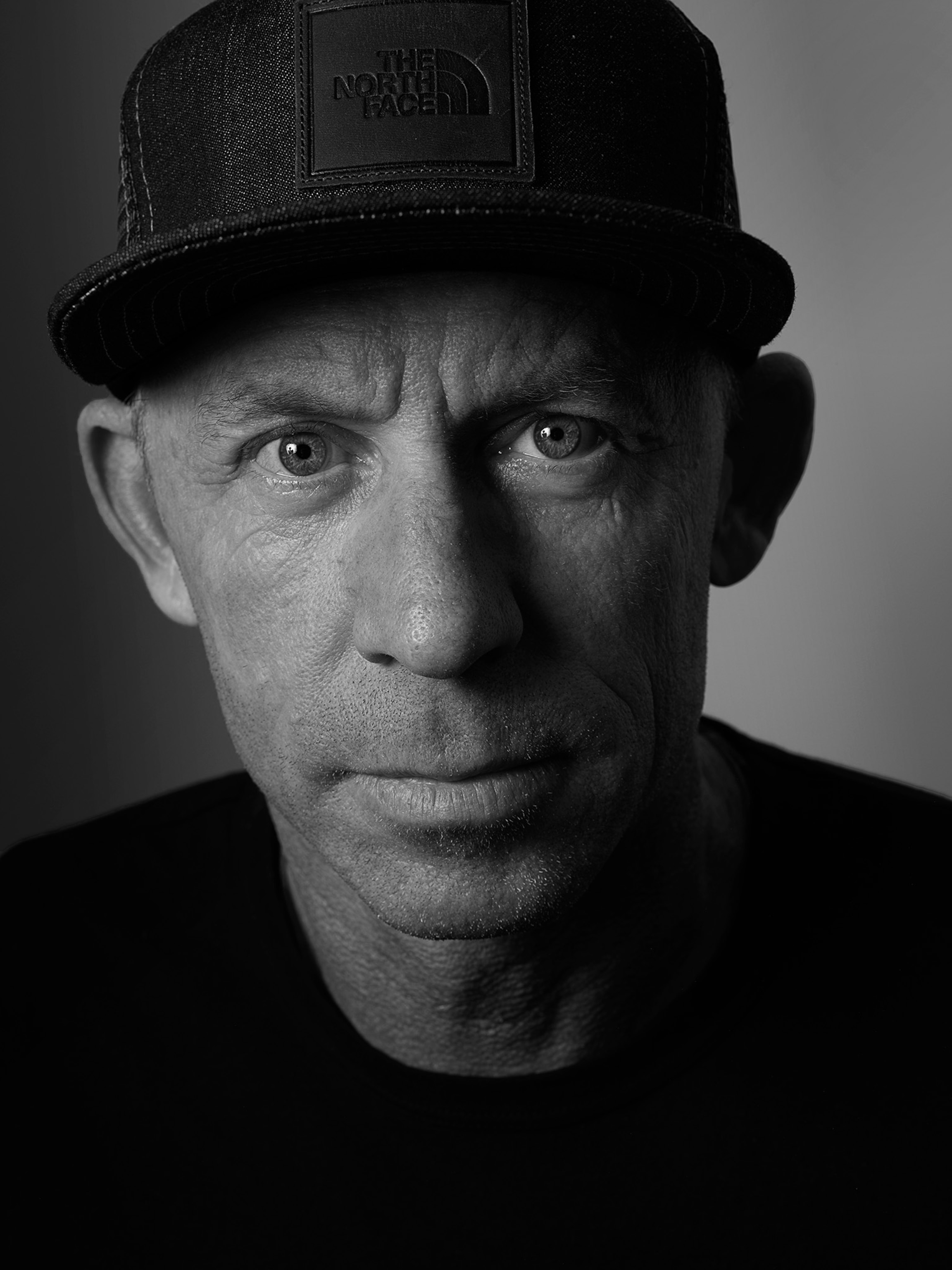 A black and white portrait of a person, whose face is lit partially