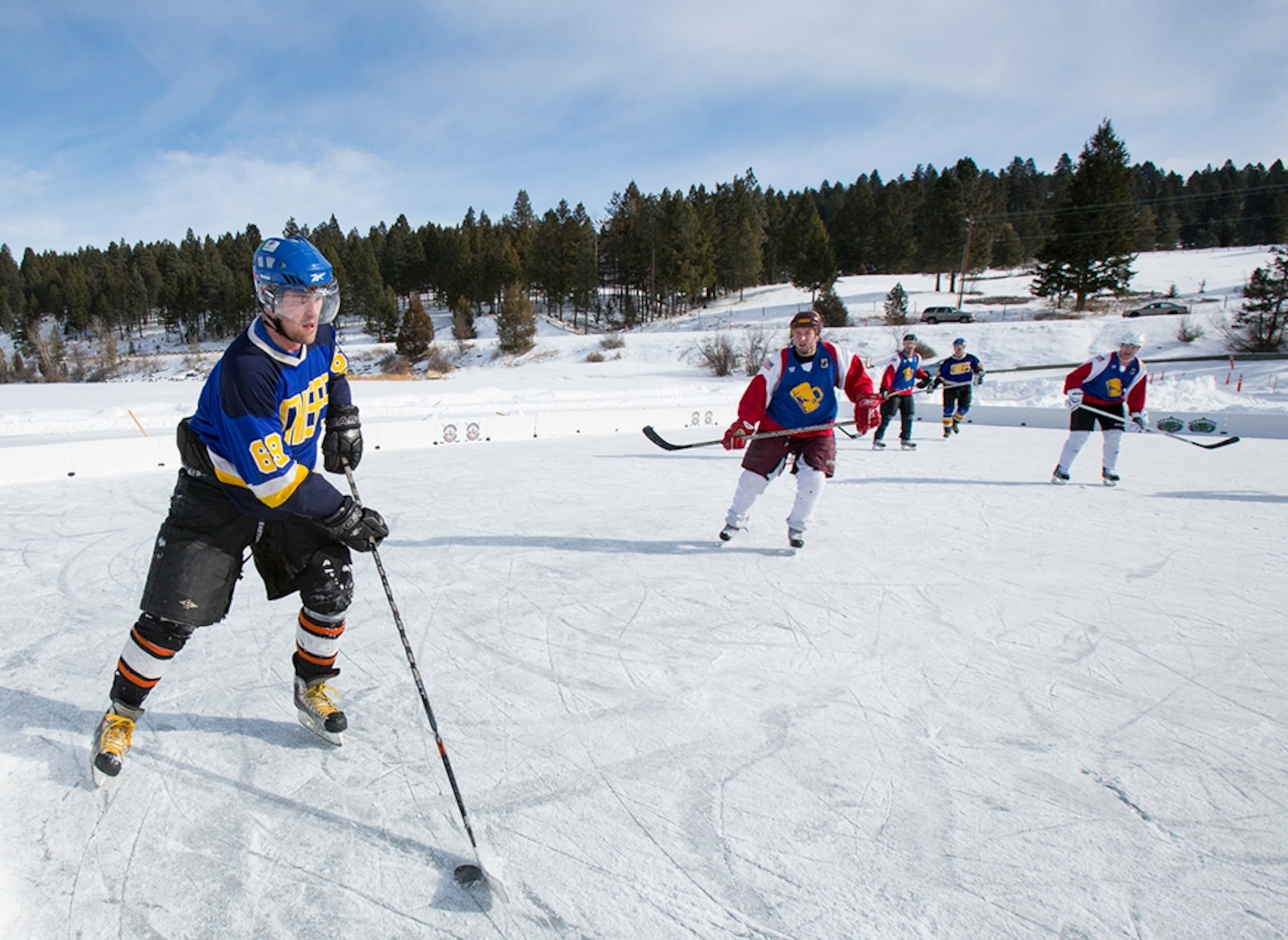 men playing hockey at the inaugural Montana Pond Hockey Classic held on Foys Lake in Kalispell, MT
