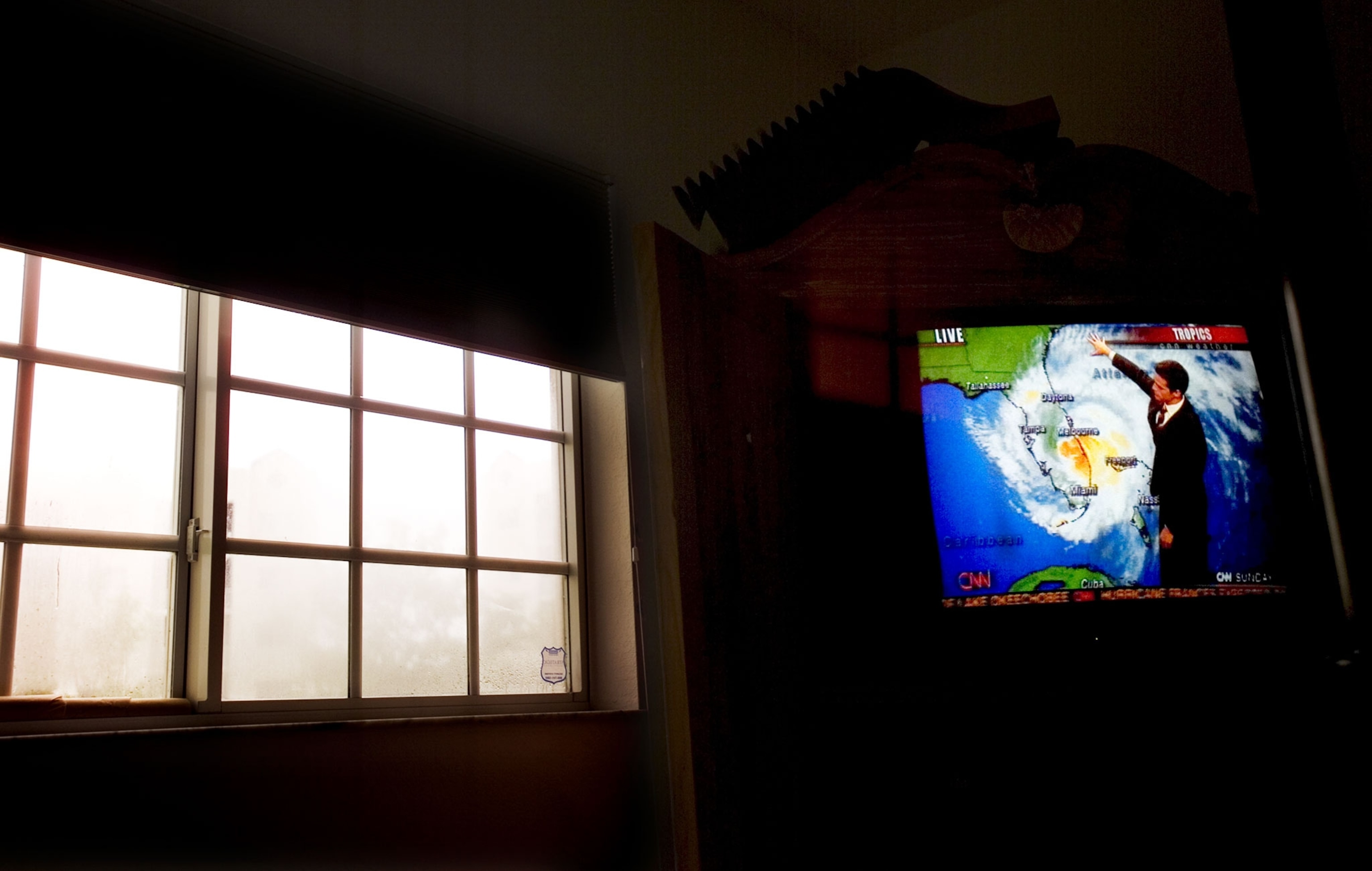 a tv weather report with storm building outside