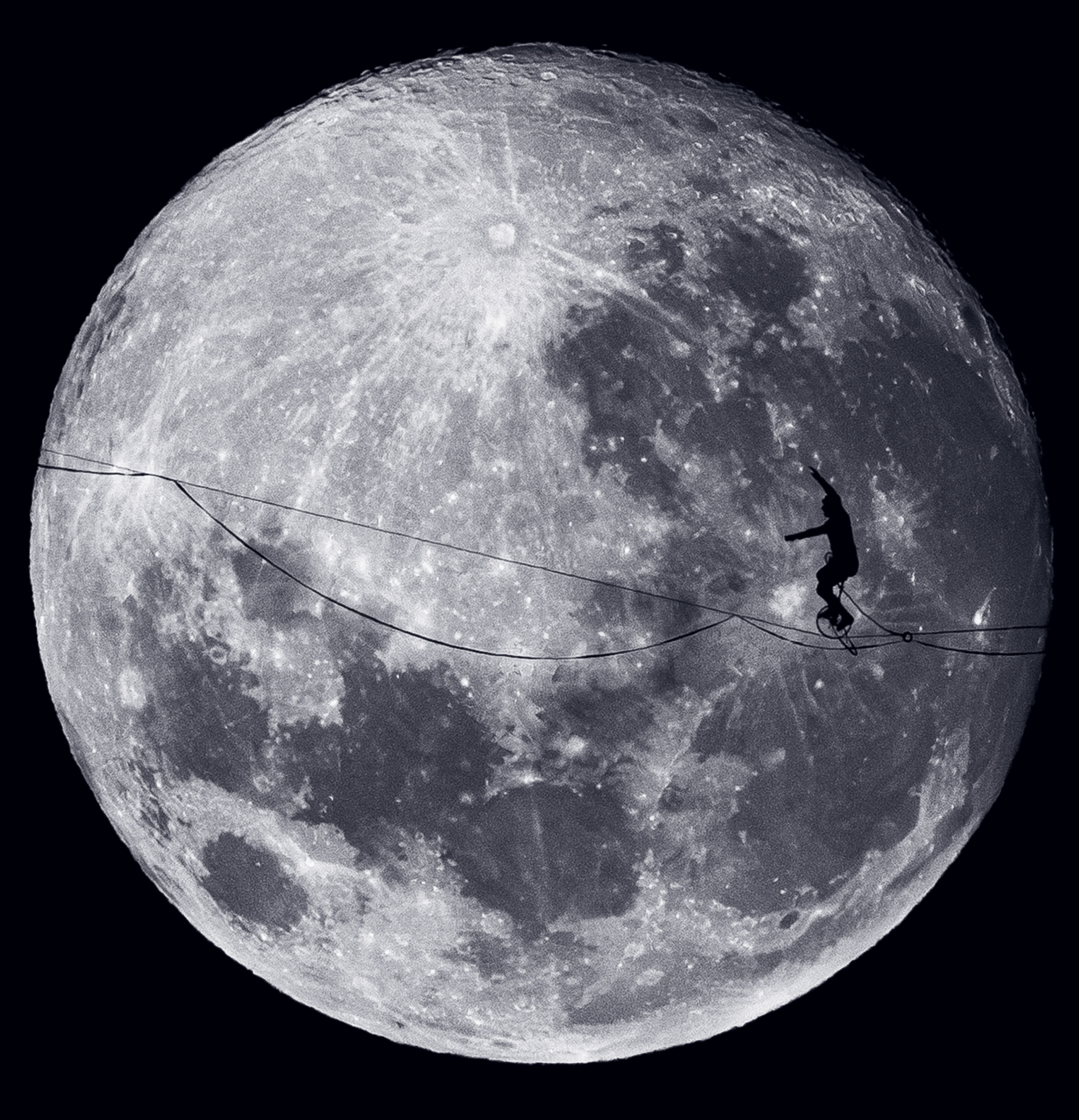 A person rides a unicycle along a tightrope with the moon behind them.