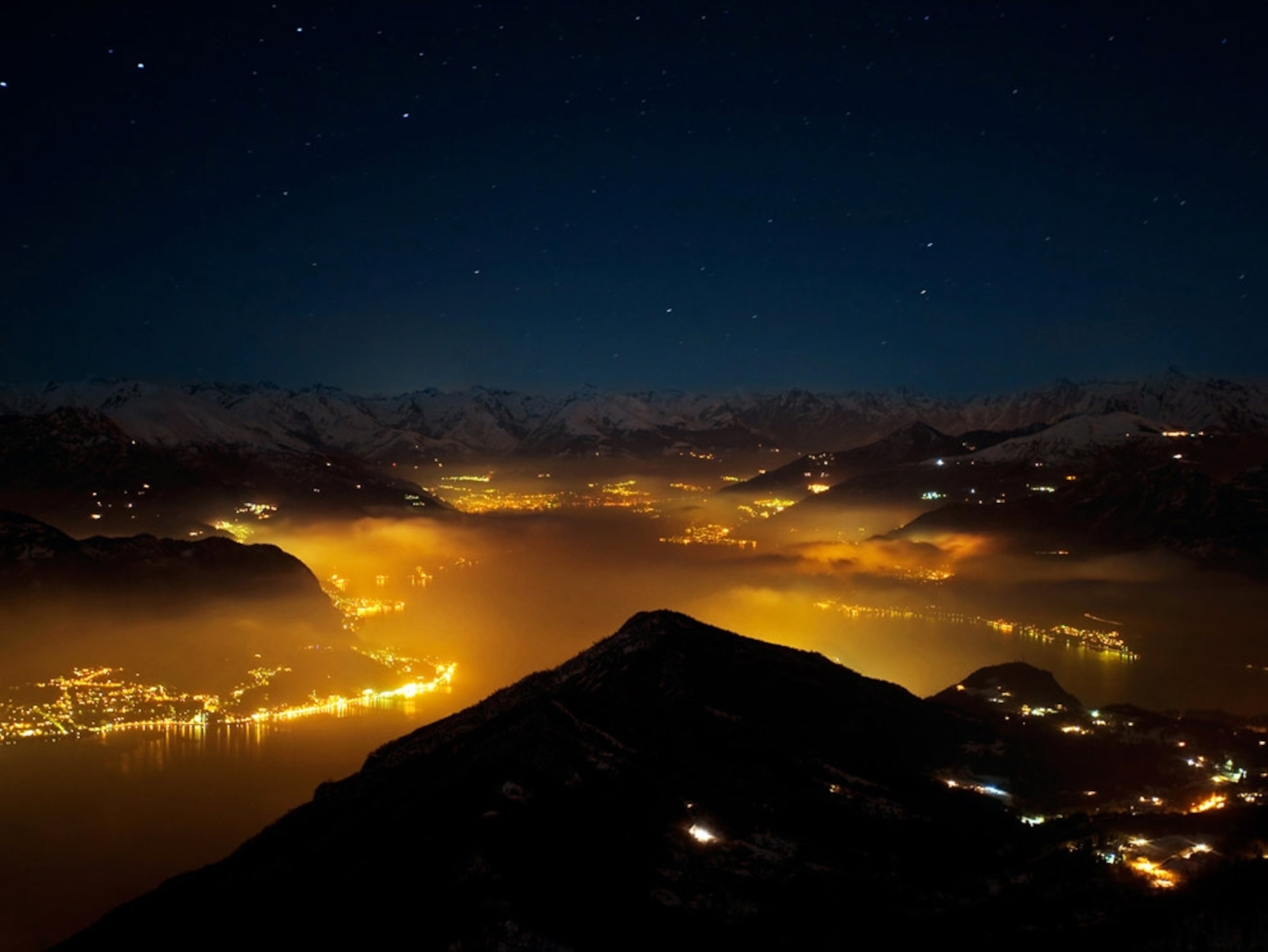 Fog diffusing lights surrounding a lake at night