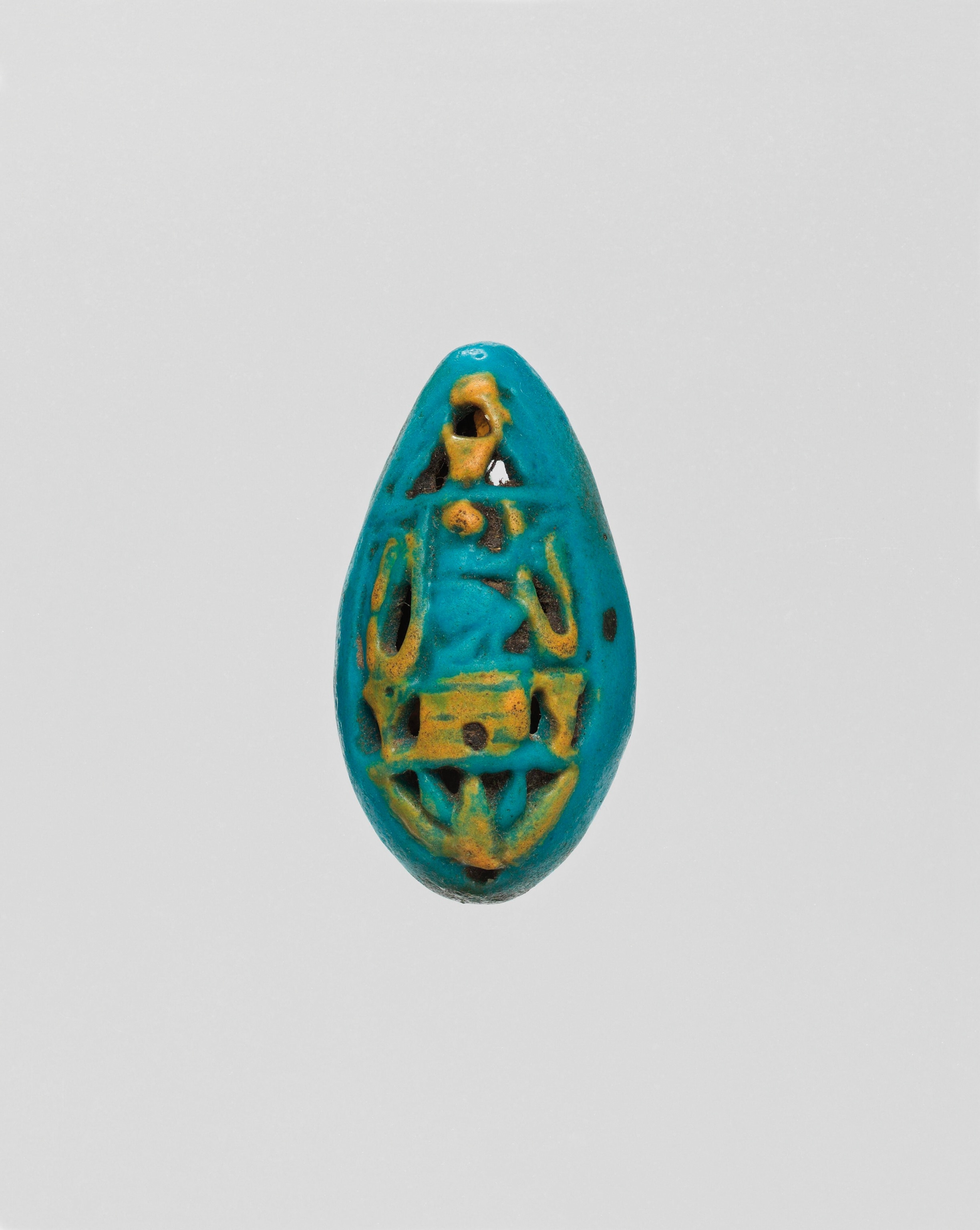 Ancient Egyptian openwork bead with crouching central figure.