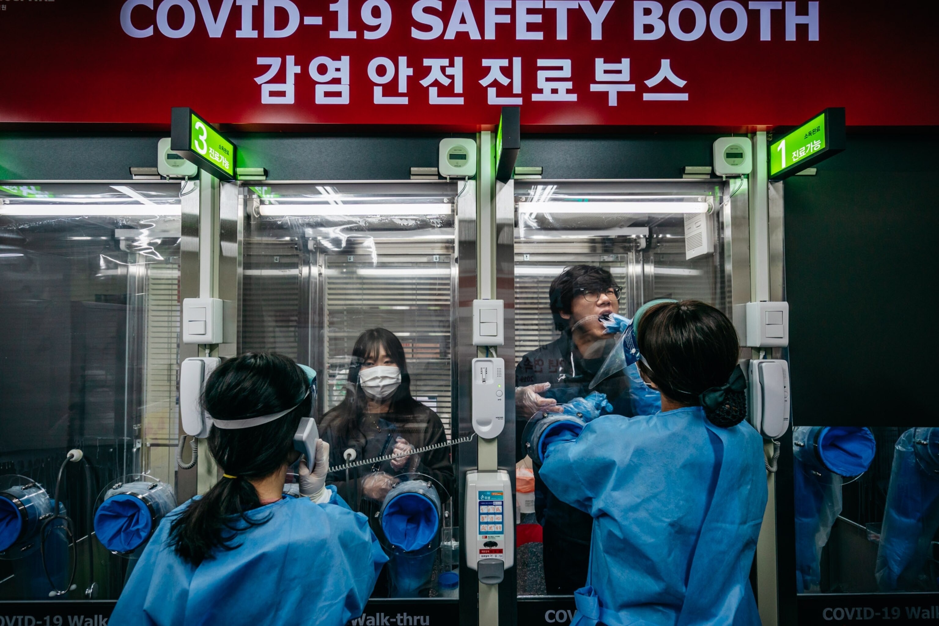 two people being tested at a covid testing booth station