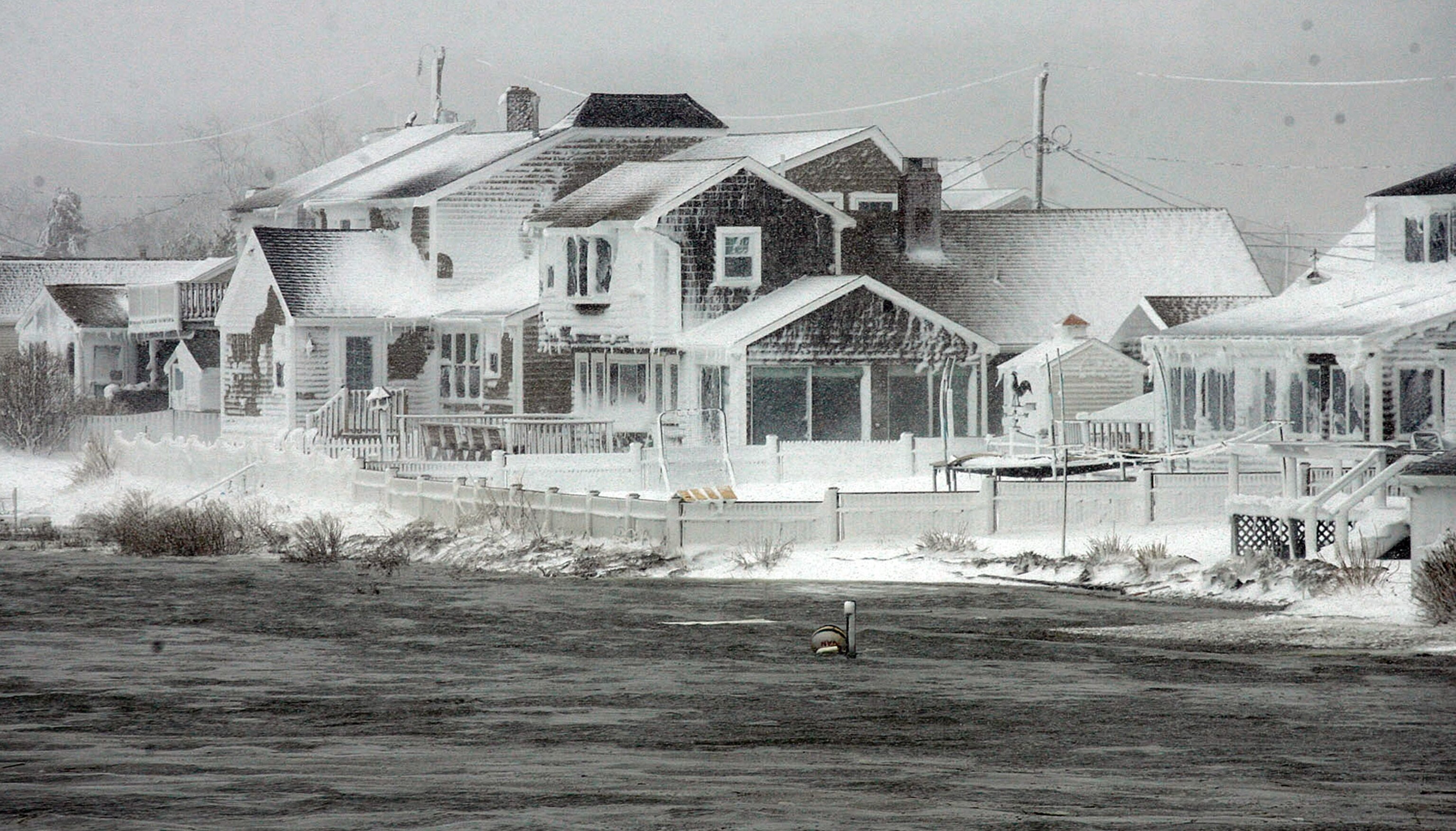 Wet snow on riverfront houses in Massachusetts