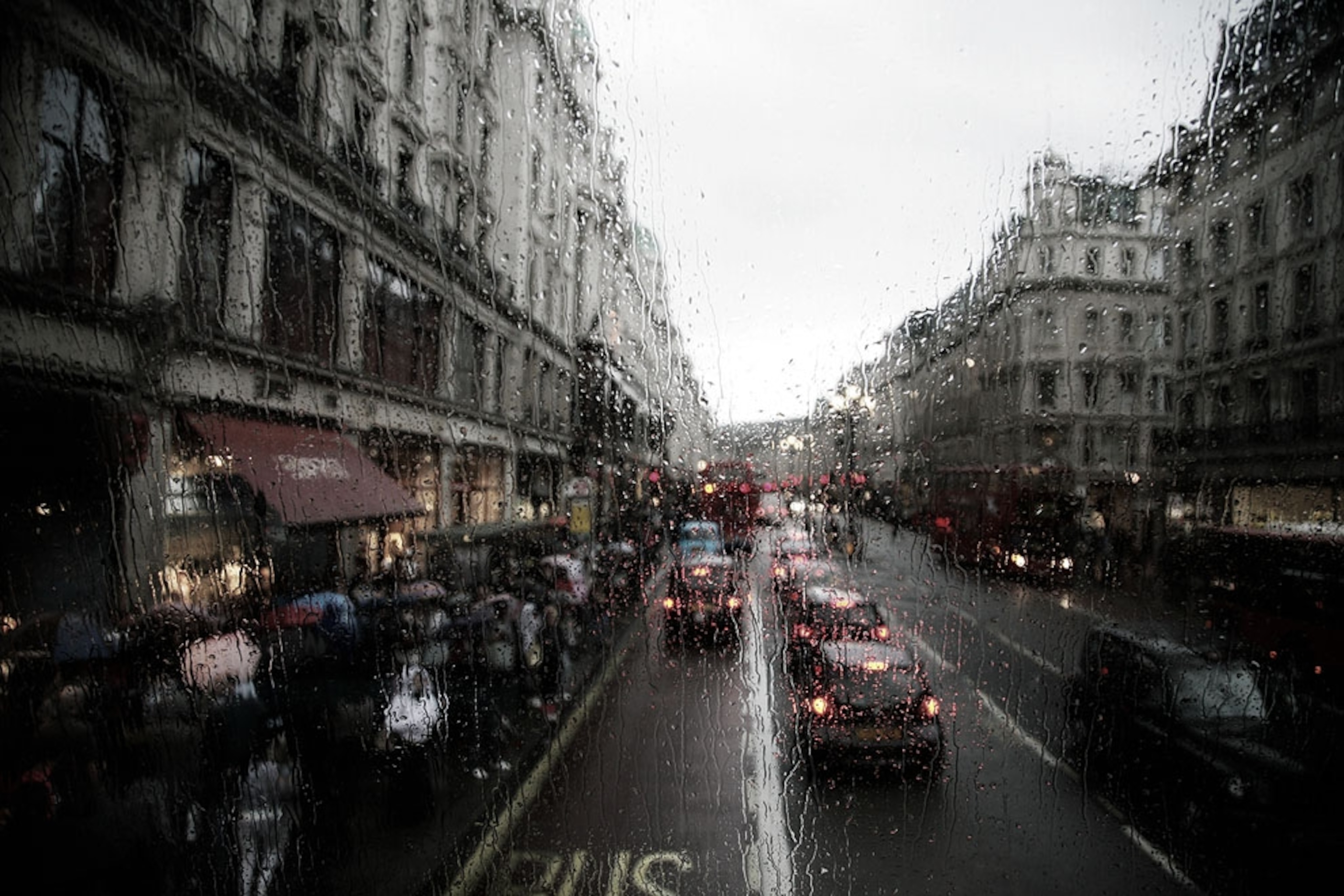 A rainy street scene shot from a London bus