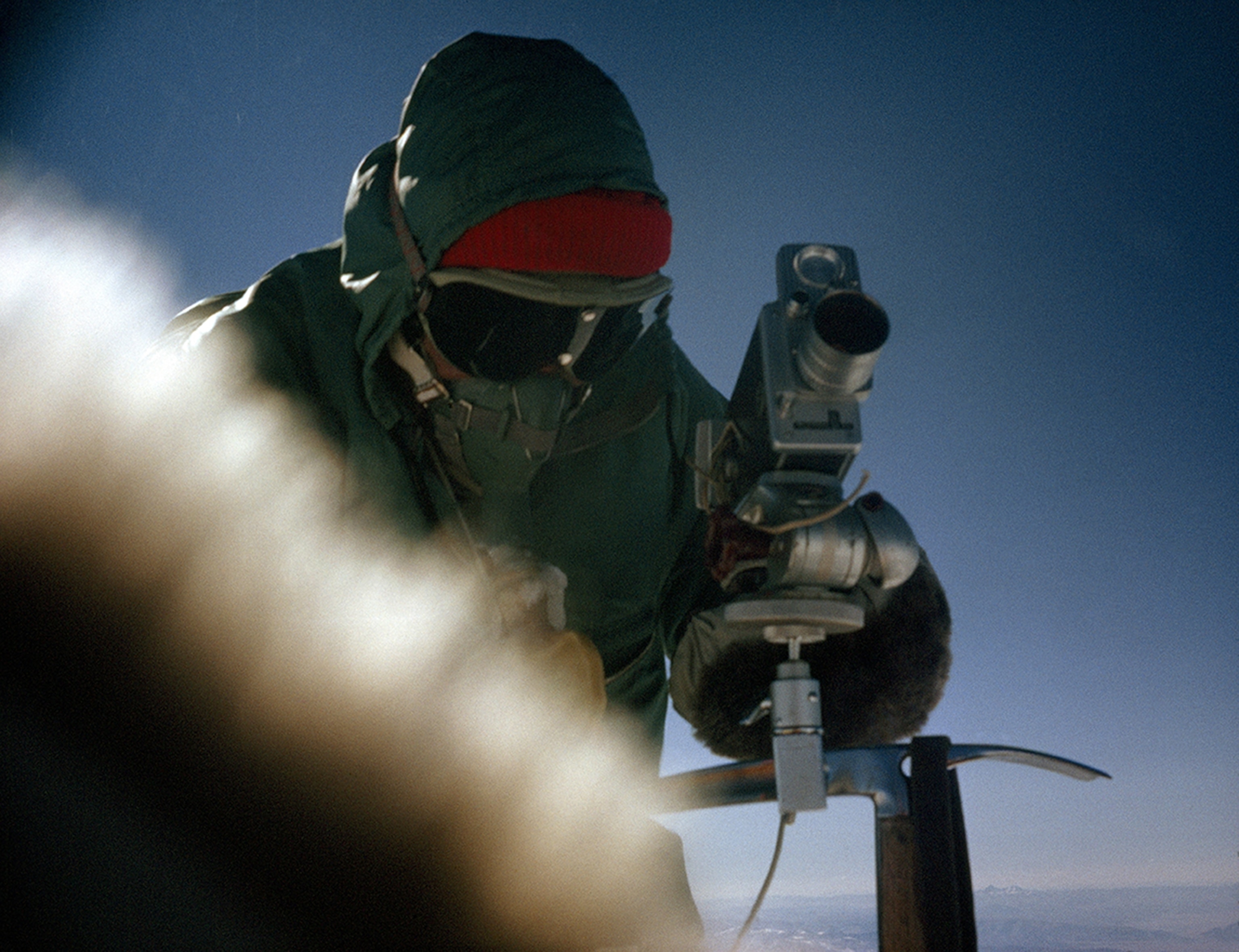 Camera steadied on ice ax, Jerstad takes the first motion pictures ever made on the crest of Everest.