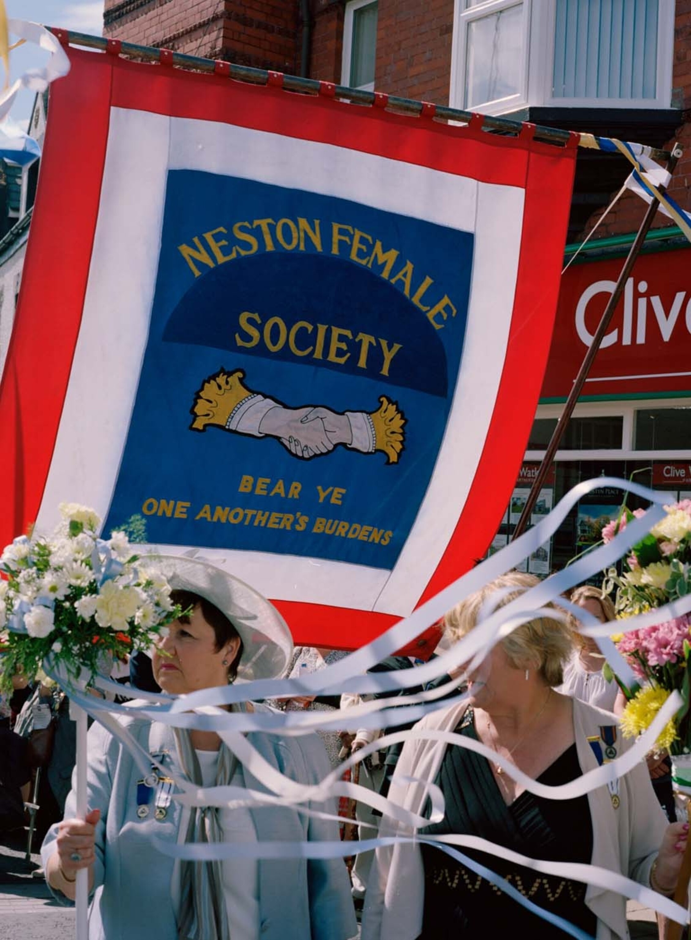 women carrying large banner