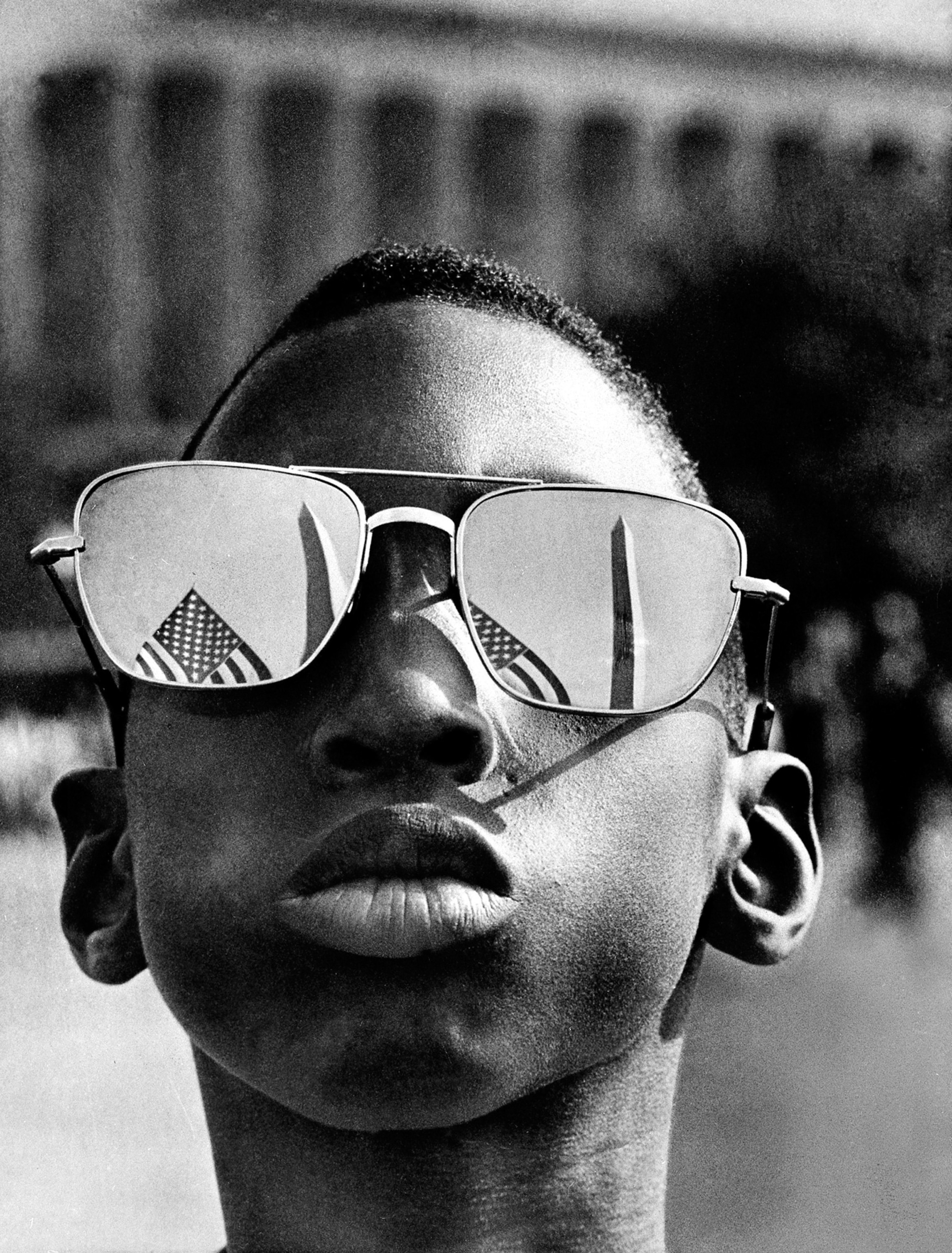 The Washington Monument and a U.S. flag are reflected in the sunglasses of Austin Clinton Brown, 9, of Gainesville, Ga., as he joins others in the March on Washington on Aug. 28, 1963. (AP Photo)